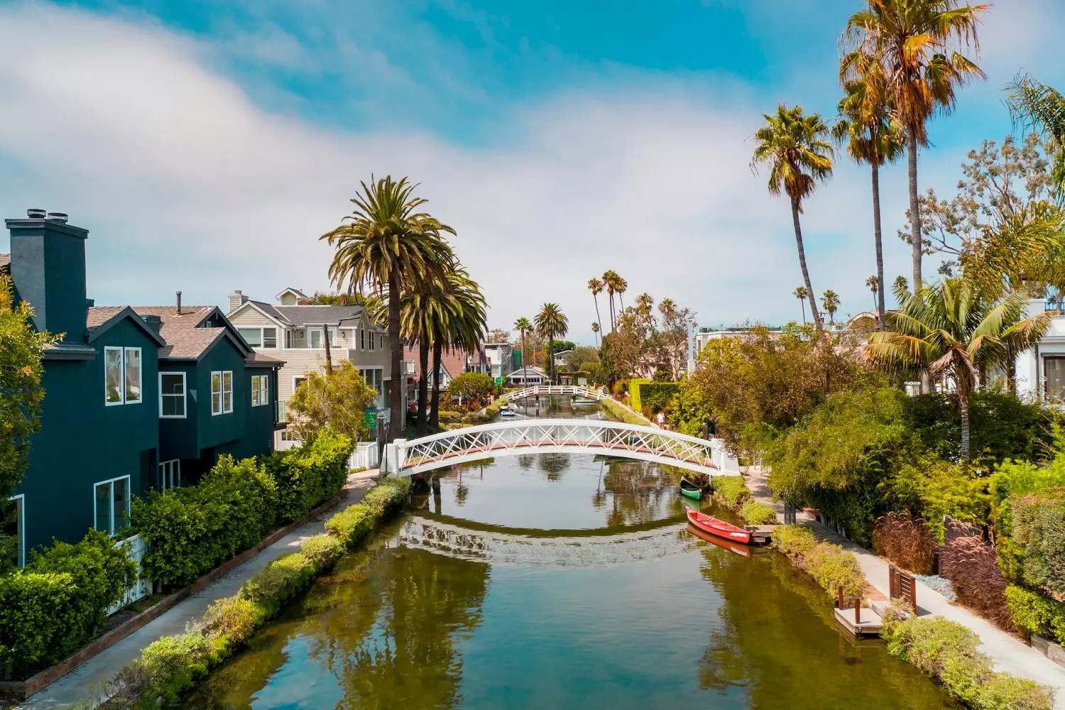 «Американская Венеция» в Калифорнии Живописный вид на Venice canals: узкий канал с лодкой и тропической растительностью