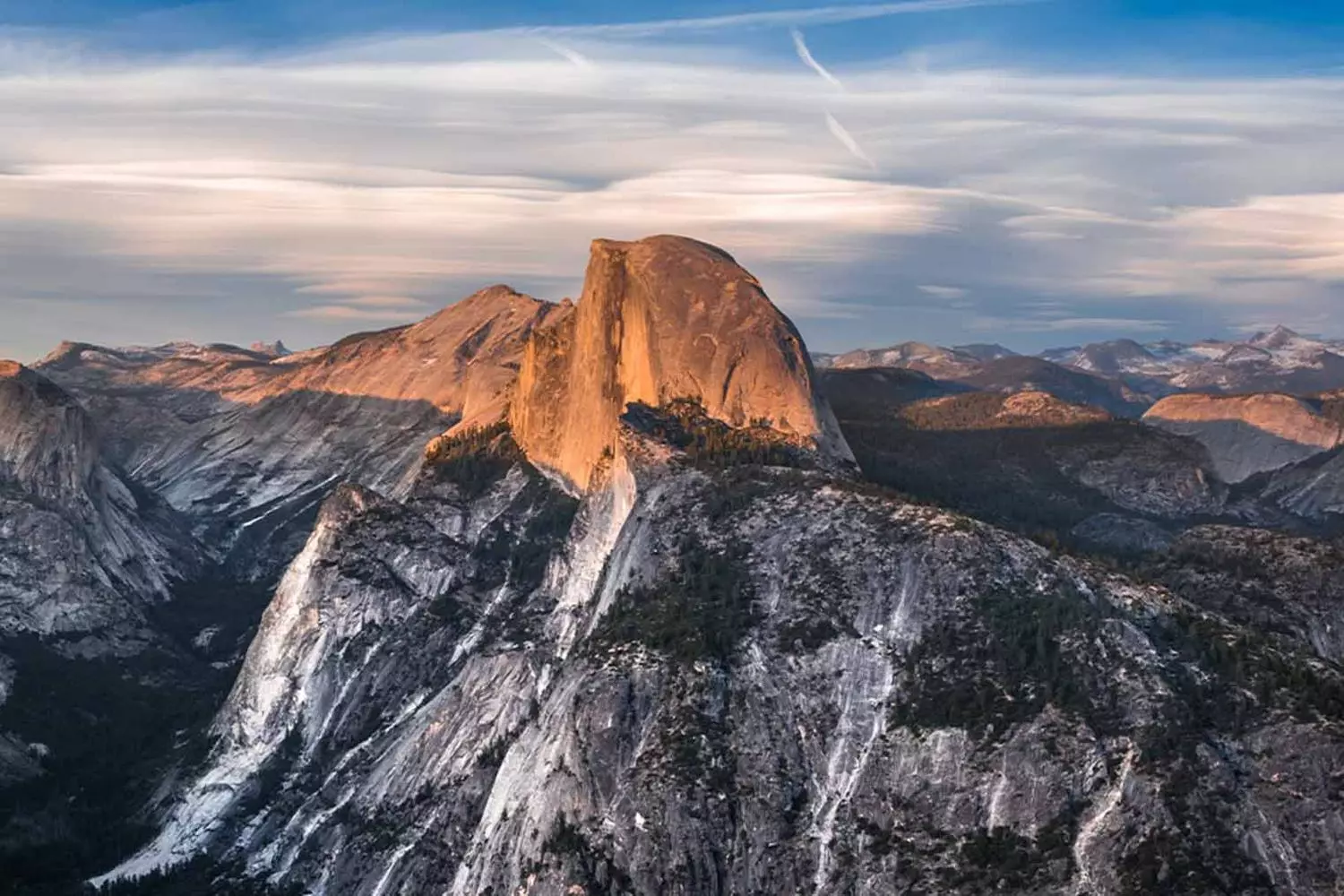 Yosemite's Untamed Beauty: A Landscape Carved by Giants Panoramic view of Yosemite National Park showcasing iconic granite cliffs, lush valleys, and cascading waterfalls under a bright blue sky