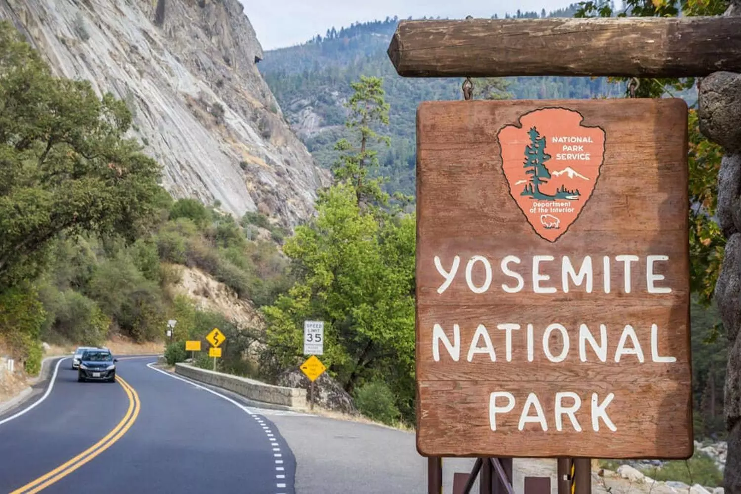 Entering Paradise: The Iconic Yosemite National Park Welcome Sign Welcome to Yosemite National Park sign surrounded by towering pine trees under a clear blue sky