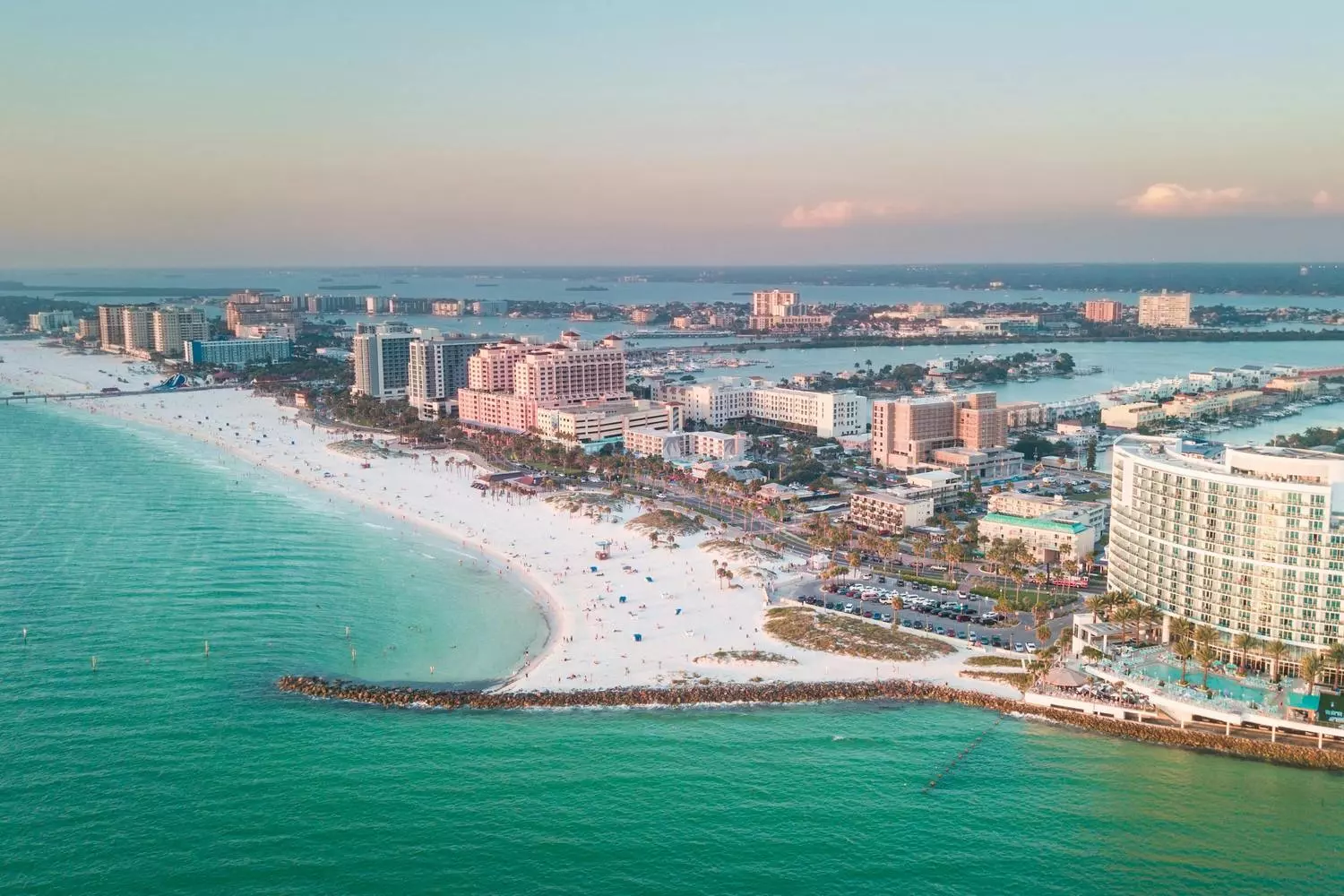 Aerial view of Clearwater Beach: pristine white sands and turquoise ocean Panoramic aerial view of Clearwater Beach: winding white-sand coastline, turquoise waters of the Gulf of Mexico, hotels and palm trees along the shore, yachts at the marina