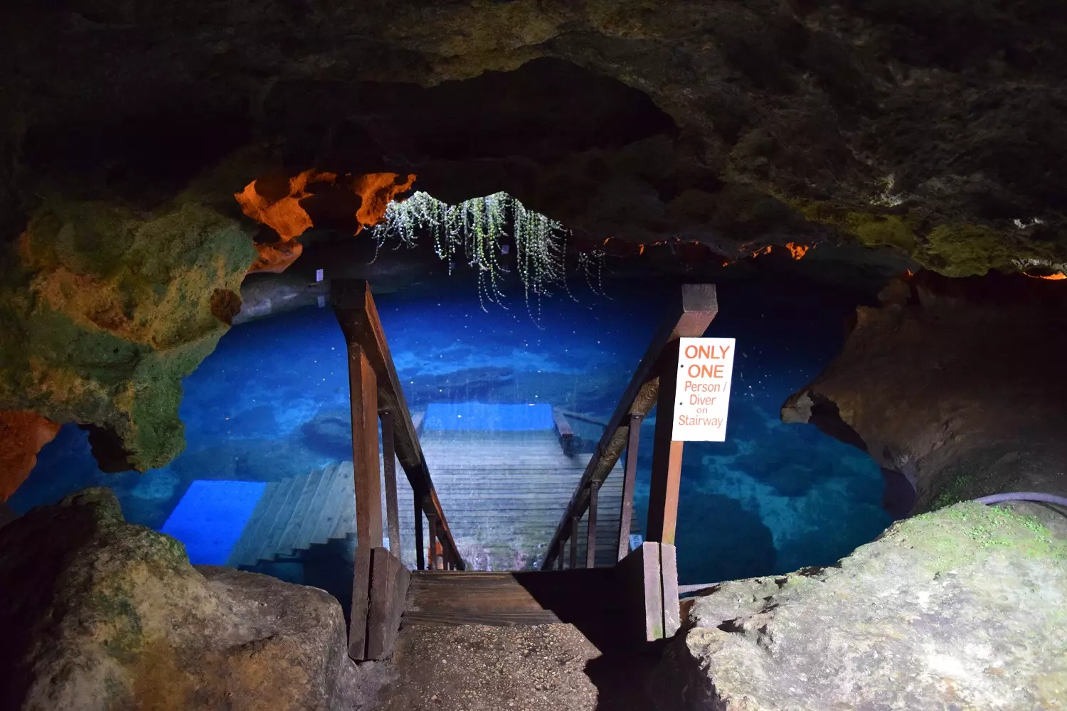 A descent to the underground lake A descent to the underground lake with a wooden staircase and crystal-clear water