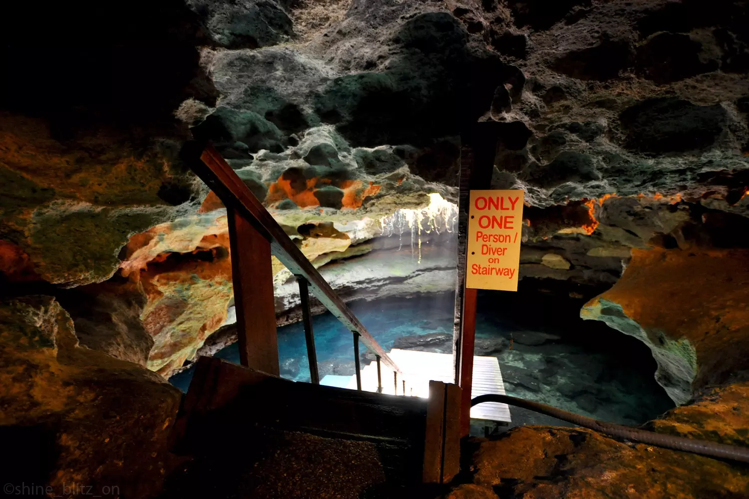 The mystical Devil’s Den cave with a crystal-clear lake A staircase leading to a clear lake in a cave with a mysterious atmosphere