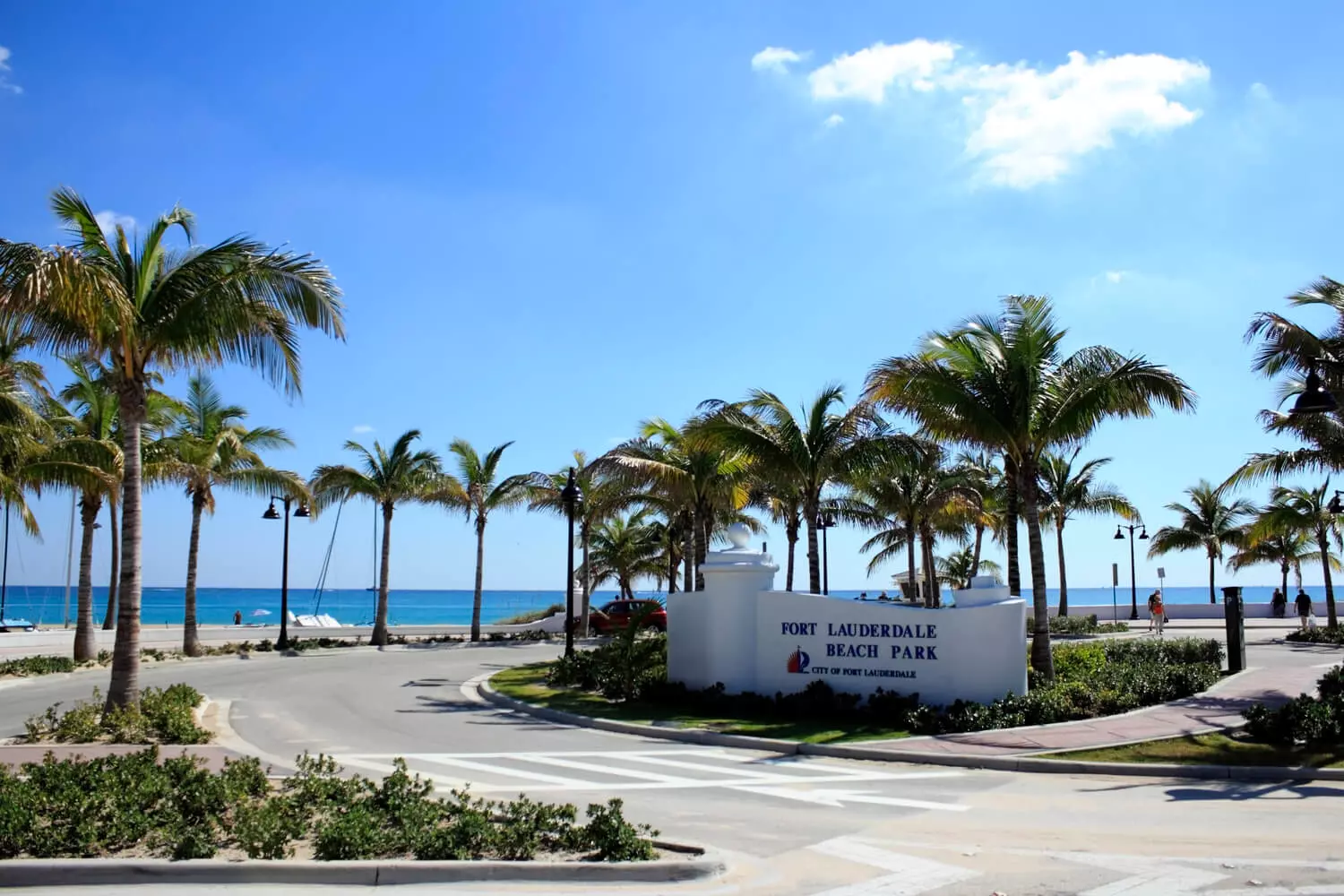 Fort Lauderdale Beach Park: A Tropical Paradise for Sun and Sea Lovers The sunny park of Fort Lauderdale Beach with golden sand, turquoise waves, palm trees, and vacationers relaxing on the shore under a clear blue sky