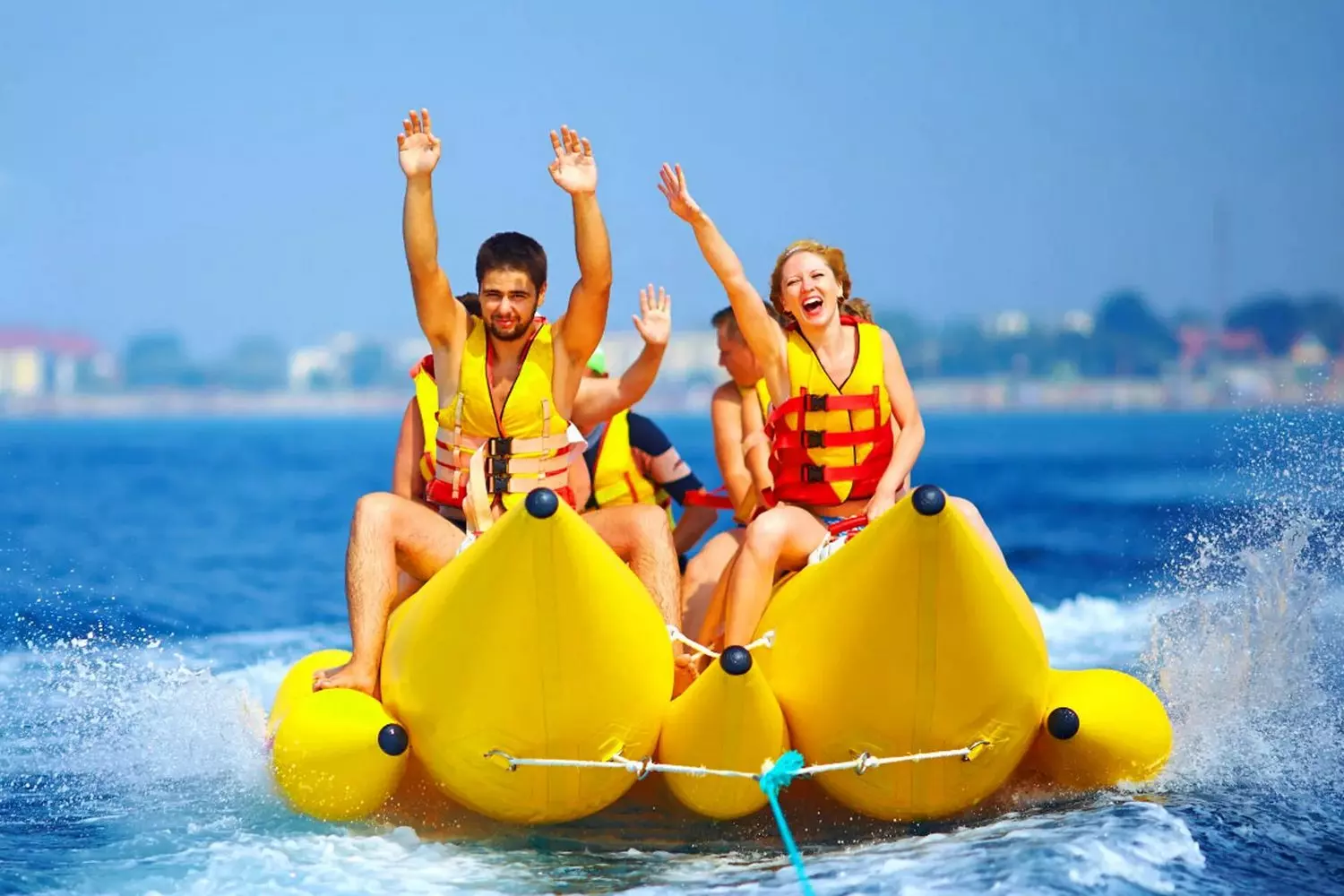 Miami Banana Boat Adventure — Thrills and Splashes Yellow inflatable banana boat with laughing riders in Miami waters