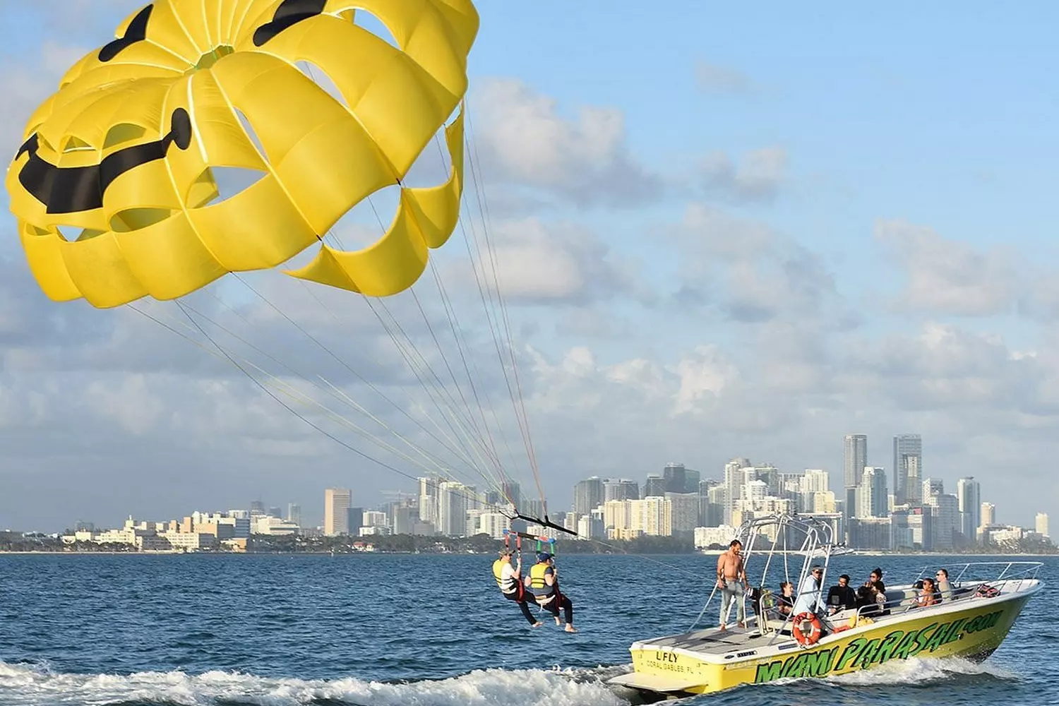 Miami Parasailing Adventure — Fly High Over the Ocean Parasailers soaring above Miami's turquoise waters under blue skies