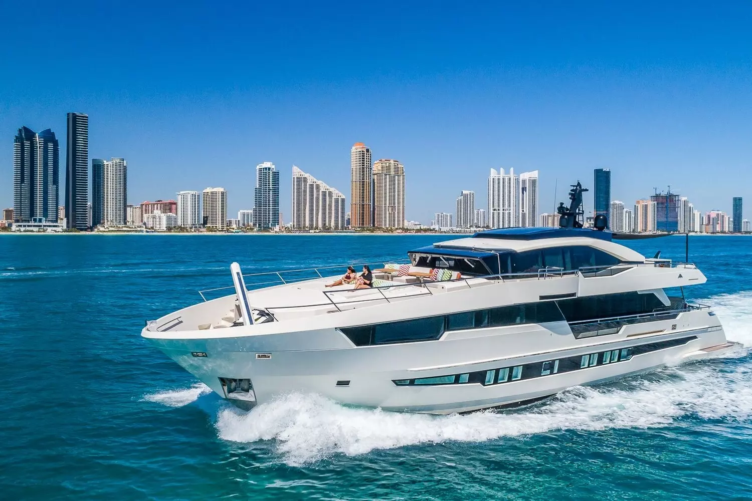 Private Yacht Experience in Miami — Glamour and Ocean Breezes White luxury motor yacht cruising through Miami Bay with downtown panorama