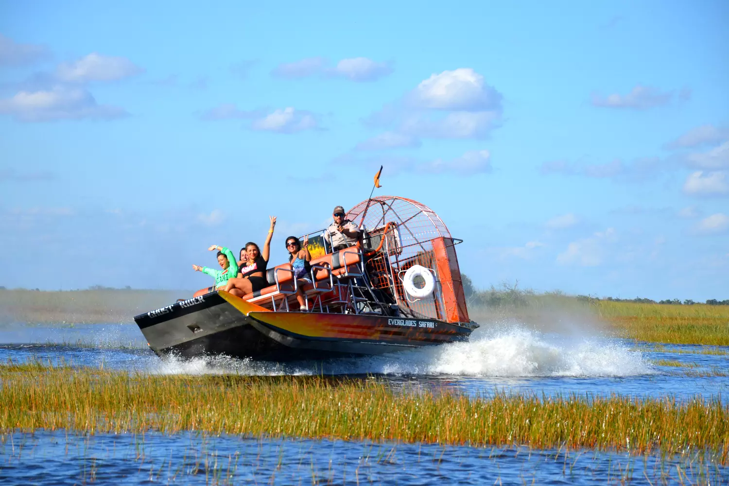 Everglades Airboat Tour — A Thrilling Tour of Natural Wetlands Tourists on an airboat in the Everglades National Park during a walk through the swamps