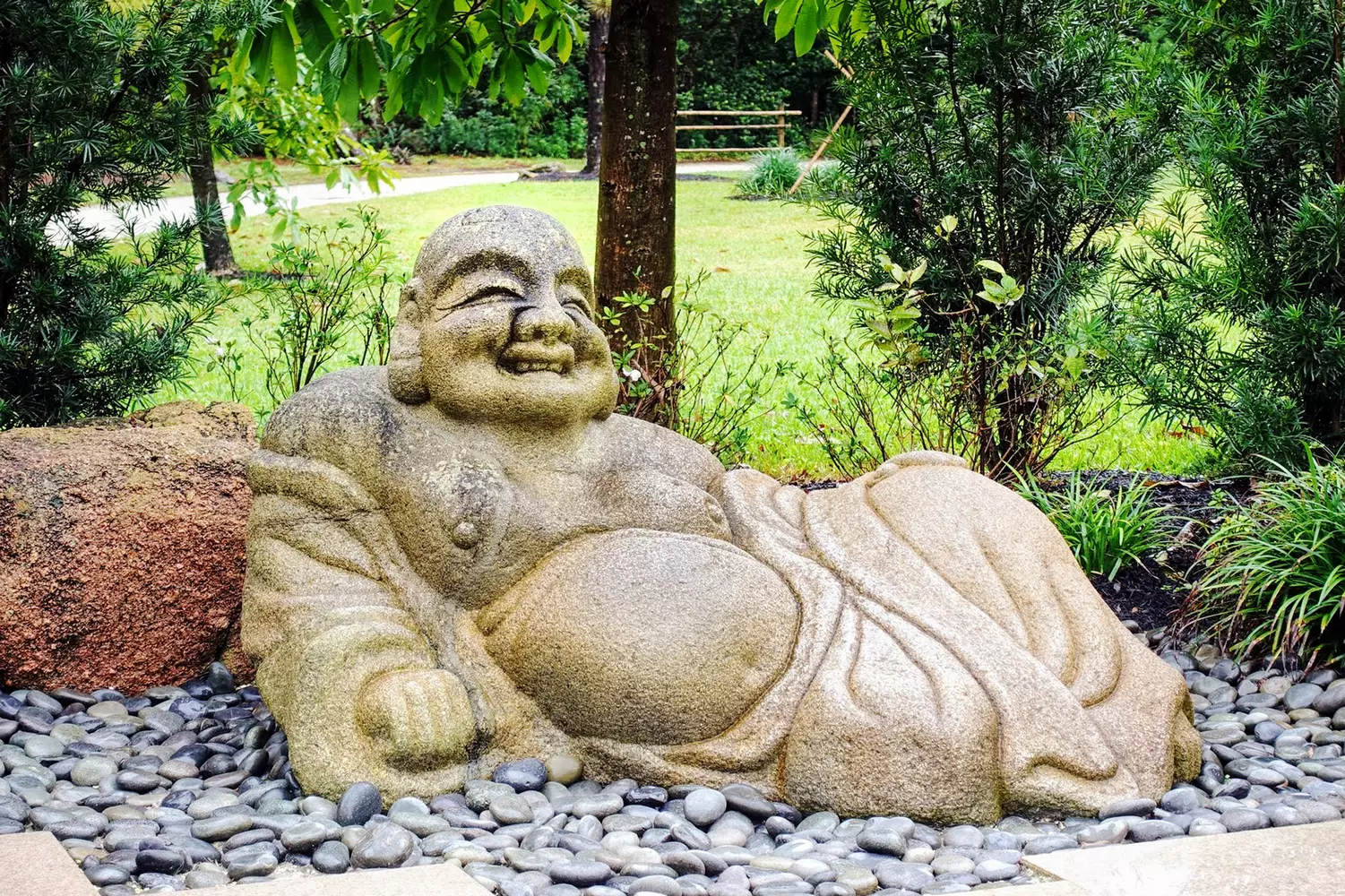 Buddha in Morikami Gardens — a symbol of peace and Eastern philosophy Statue in the Morikami Museum and Japanese Gardens, Florida, surrounded by greenery and stones