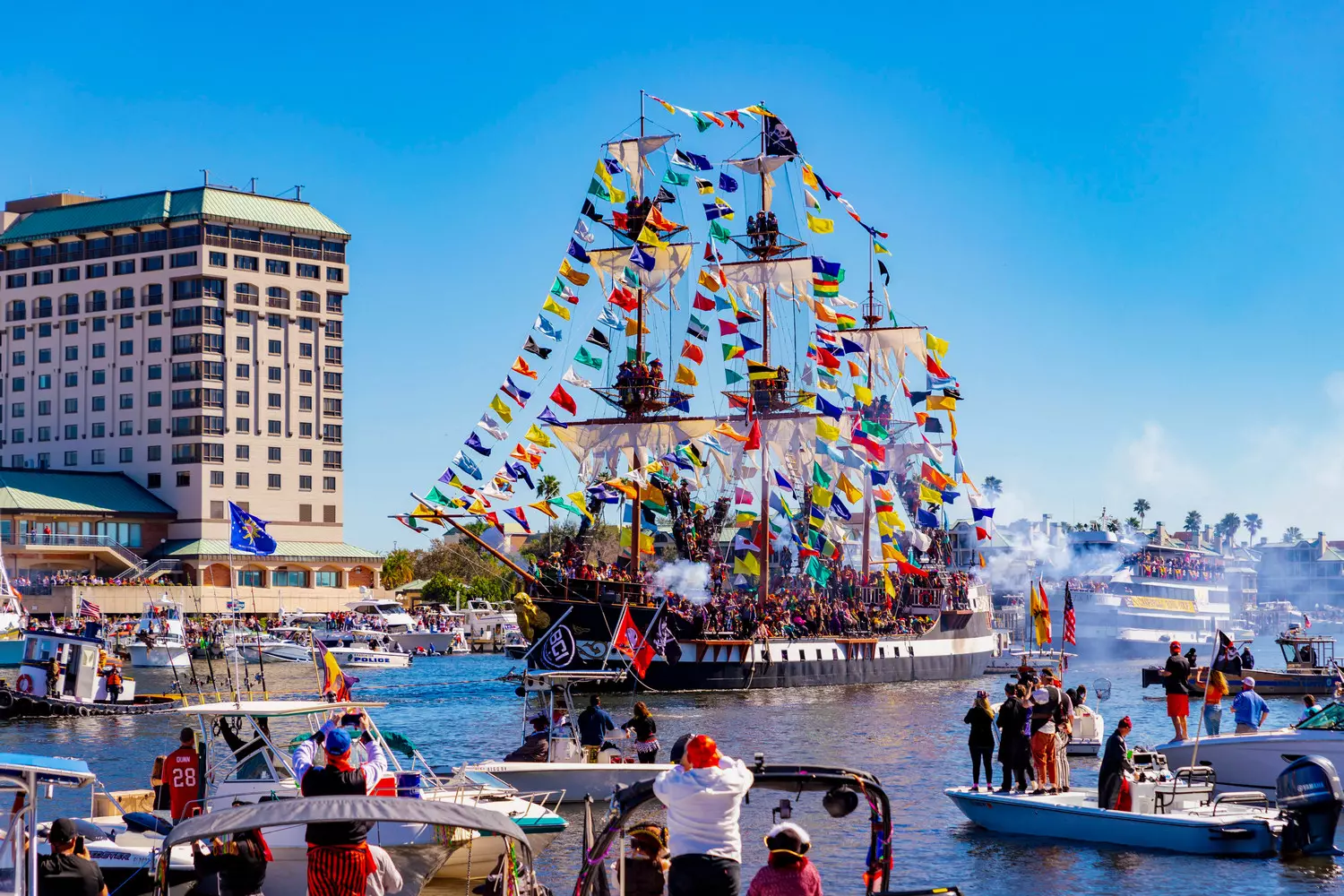 Tampa Pirate Festival — Swashbuckling Fun & Coastal Adventures A lively scene from the Tampa Pirate Festival with costumed pirates, historic ships, and crowds enjoying waterfront festivities under a sunny sky