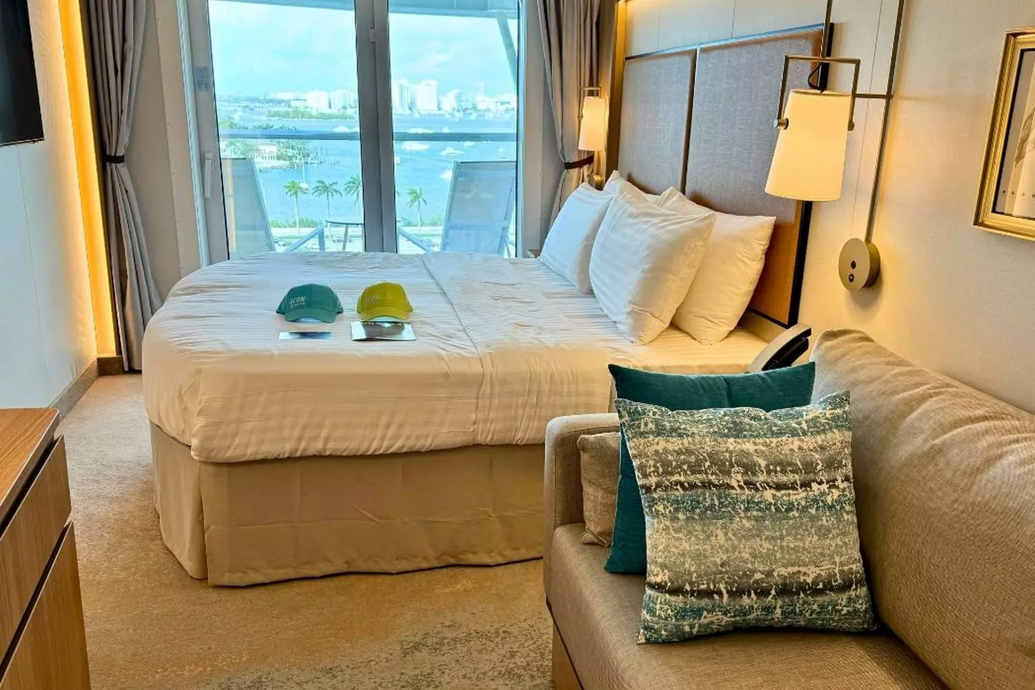 Your Sea Sanctuary: Icon of the Seas' Stunning Staterooms & Suites Luxurious stateroom aboard Icon of the Seas cruise ship featuring modern design, plush bedding, and ocean views through floor-to-ceiling windows