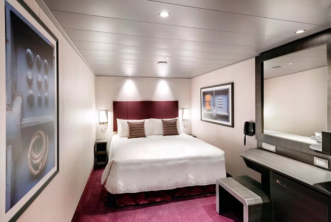 Luxurious Stateroom on MSC Meraviglia — Your Private Retreat at Sea Elegant cabin aboard MSC Meraviglia cruise ship featuring a comfortable queen bed, modern decor, and panoramic ocean views through large windows