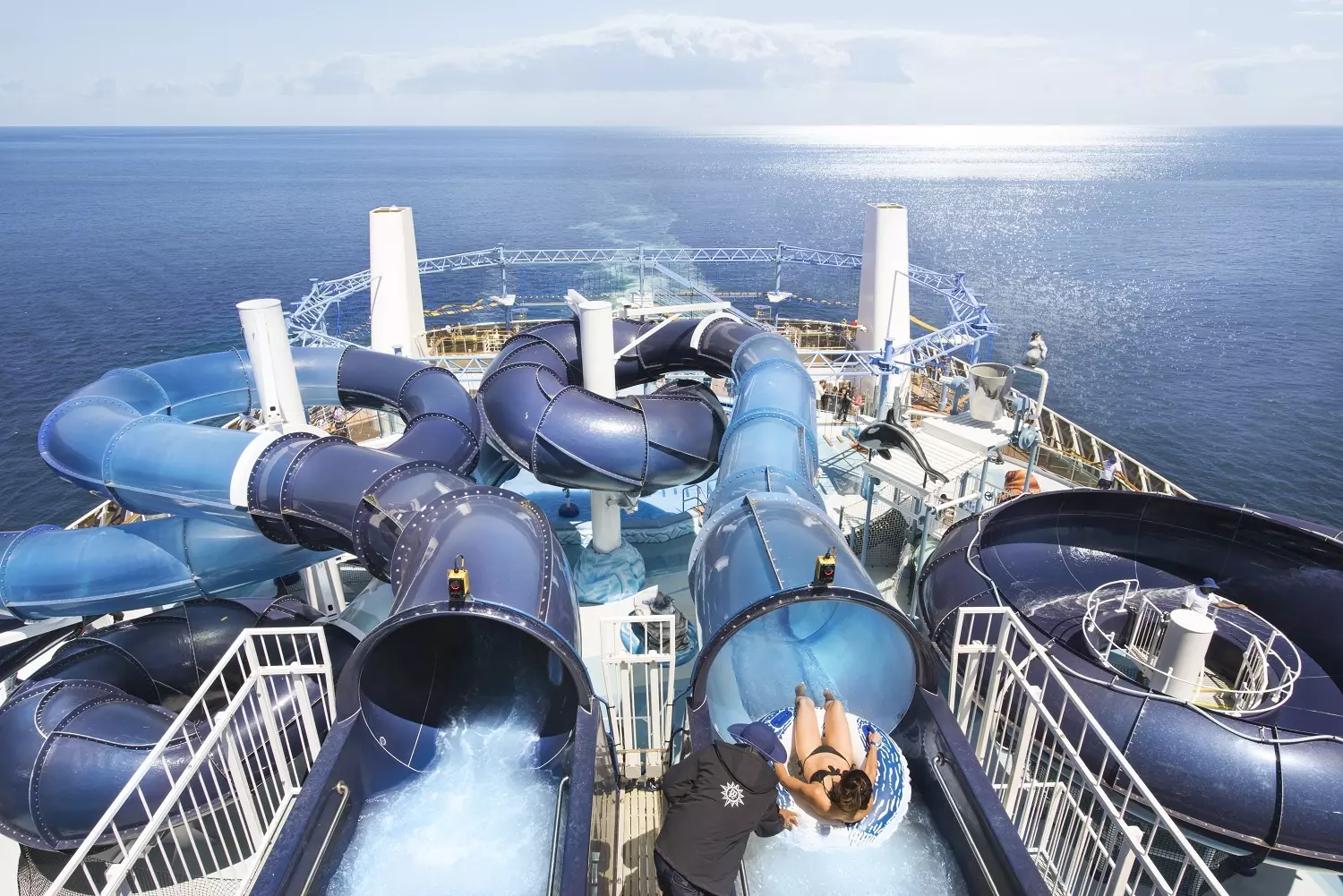 Thrilling Aqua Adventures at MSC Meraviglia's Water Park Exciting water park area on MSC Meraviglia cruise ship featuring twisting slides, splash zones, and a tropical pool atmosphere under sunny skies