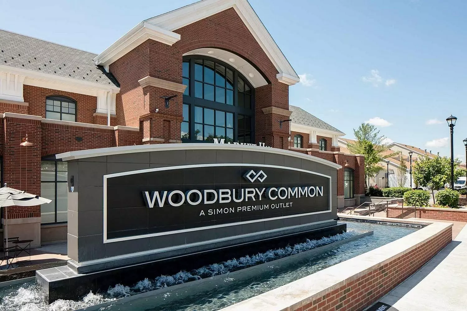 Woodbury Common Premium Outlets: Luxury Shopping Redefined Aerial view of Woodbury Common Premium Outlets showcasing rows of designer boutiques, landscaped walkways, and shoppers exploring luxury brands at discounted prices in an open-air shopping village