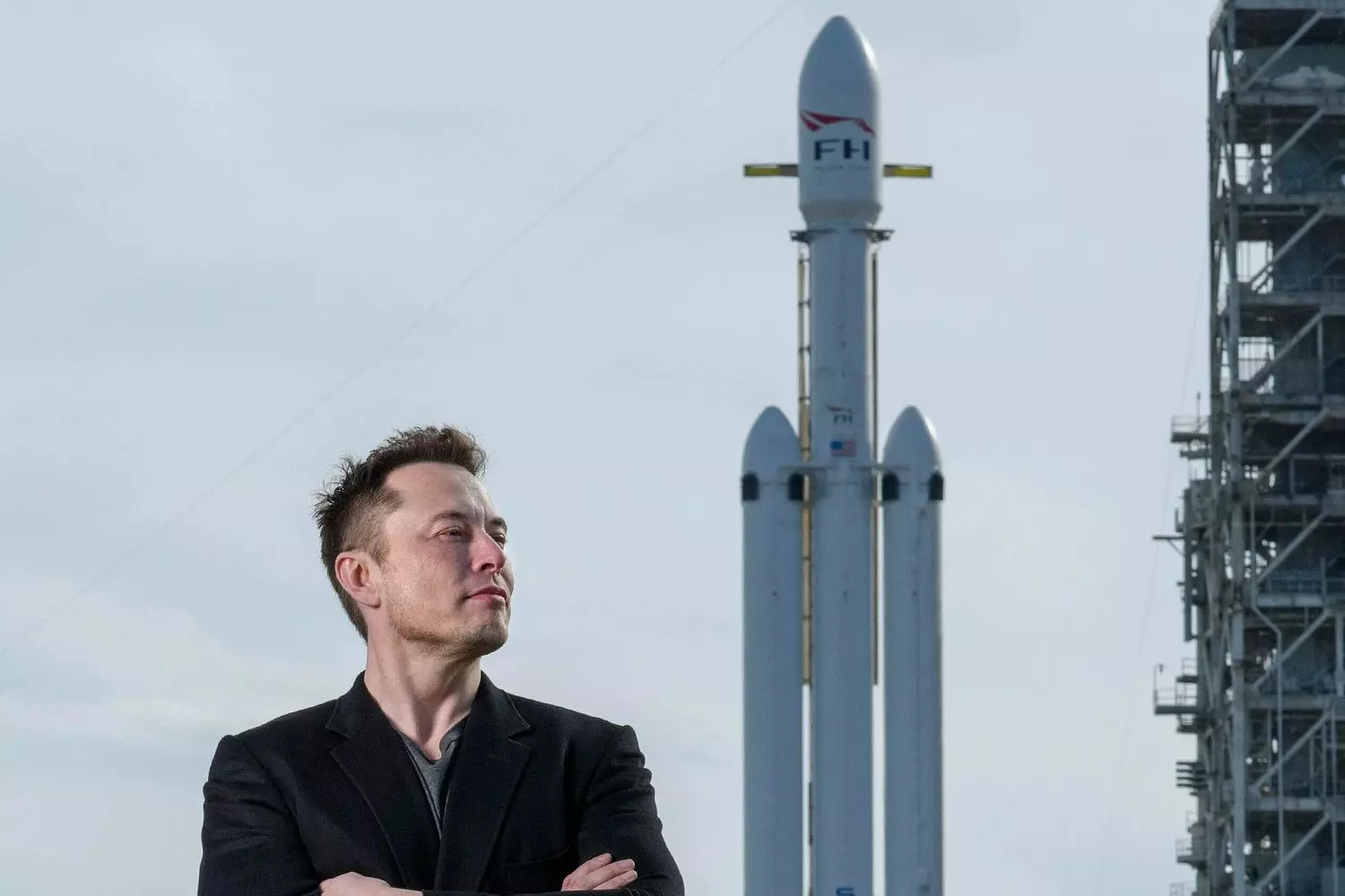 Илон Маск и ракета SpaceX: создатель и его космическое детище Илон Маск стоит на фоне ракеты SpaceX на стартовой площадке