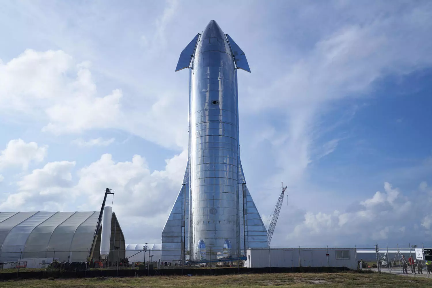 Комплекс запуска Starship: орбитальная площадка с установленной ракетой и системами поддержки Стартовая площадка Starship SpaceX в Бока-Чика с массивной пусковой башней и инфраструктурой