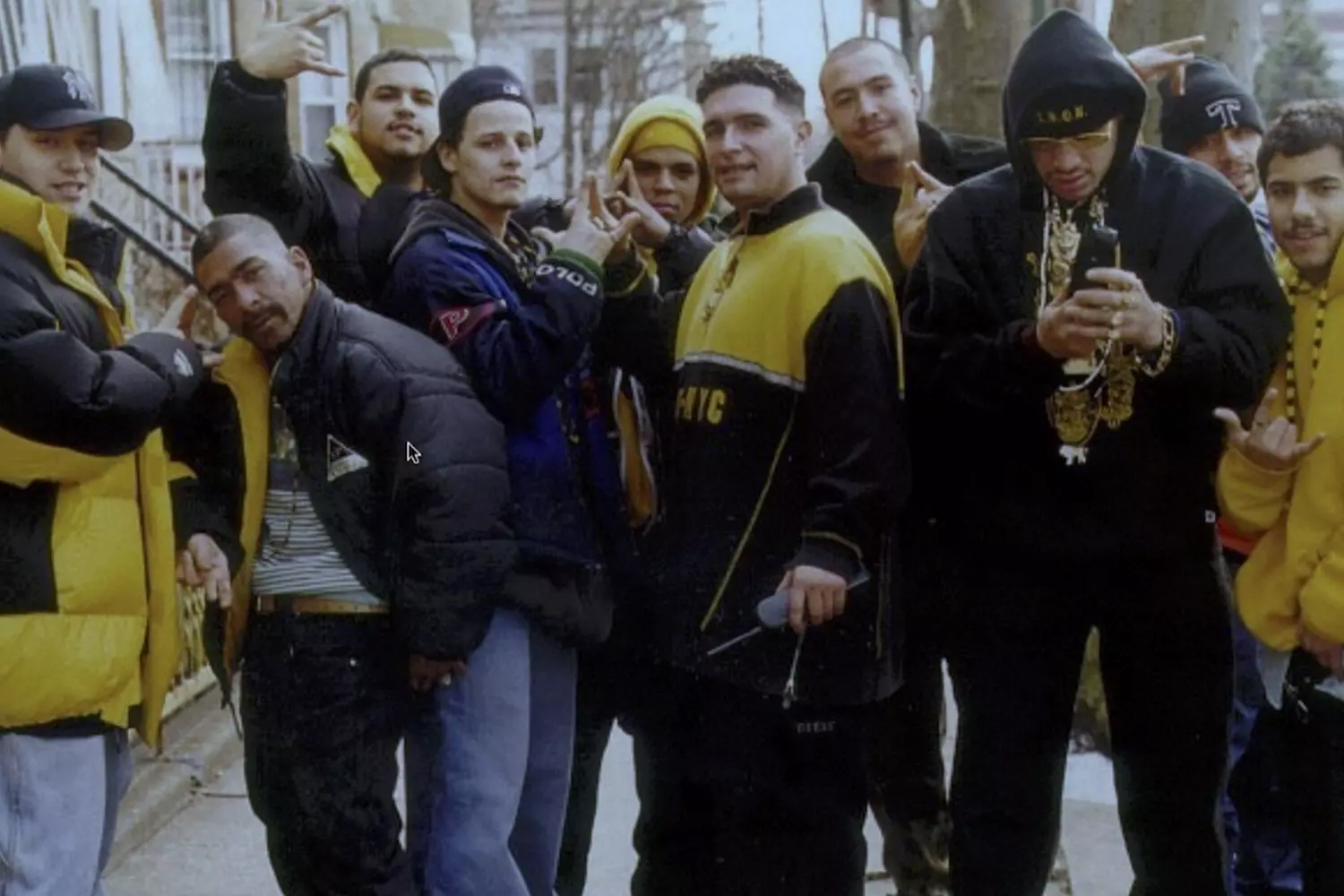Crowns of the Streets: Members of the Latin Kings Gang in the USA Members of the Latin Kings gang pose together, displaying their signature crown hand signs and wearing black and gold colors
