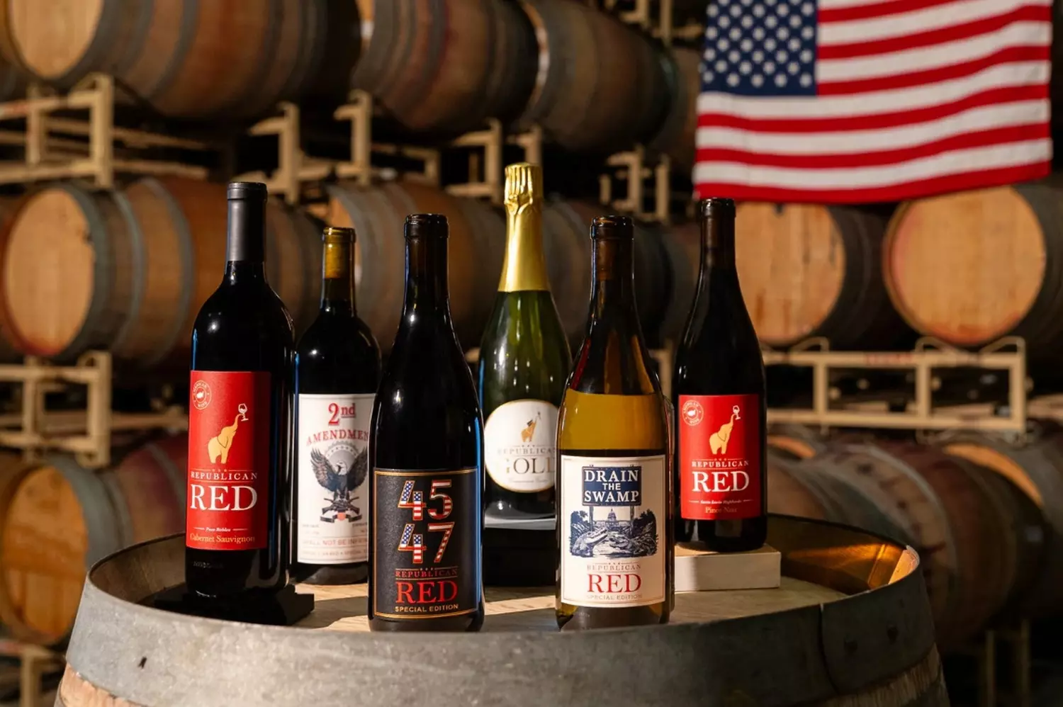 American Wine Excellence: Premium Bottles from US Vineyards Selection of high-quality American wine bottles featuring California Cabernet, Oregon Pinot Noir, and Washington Syrah beautifully arranged on a rustic wooden table
