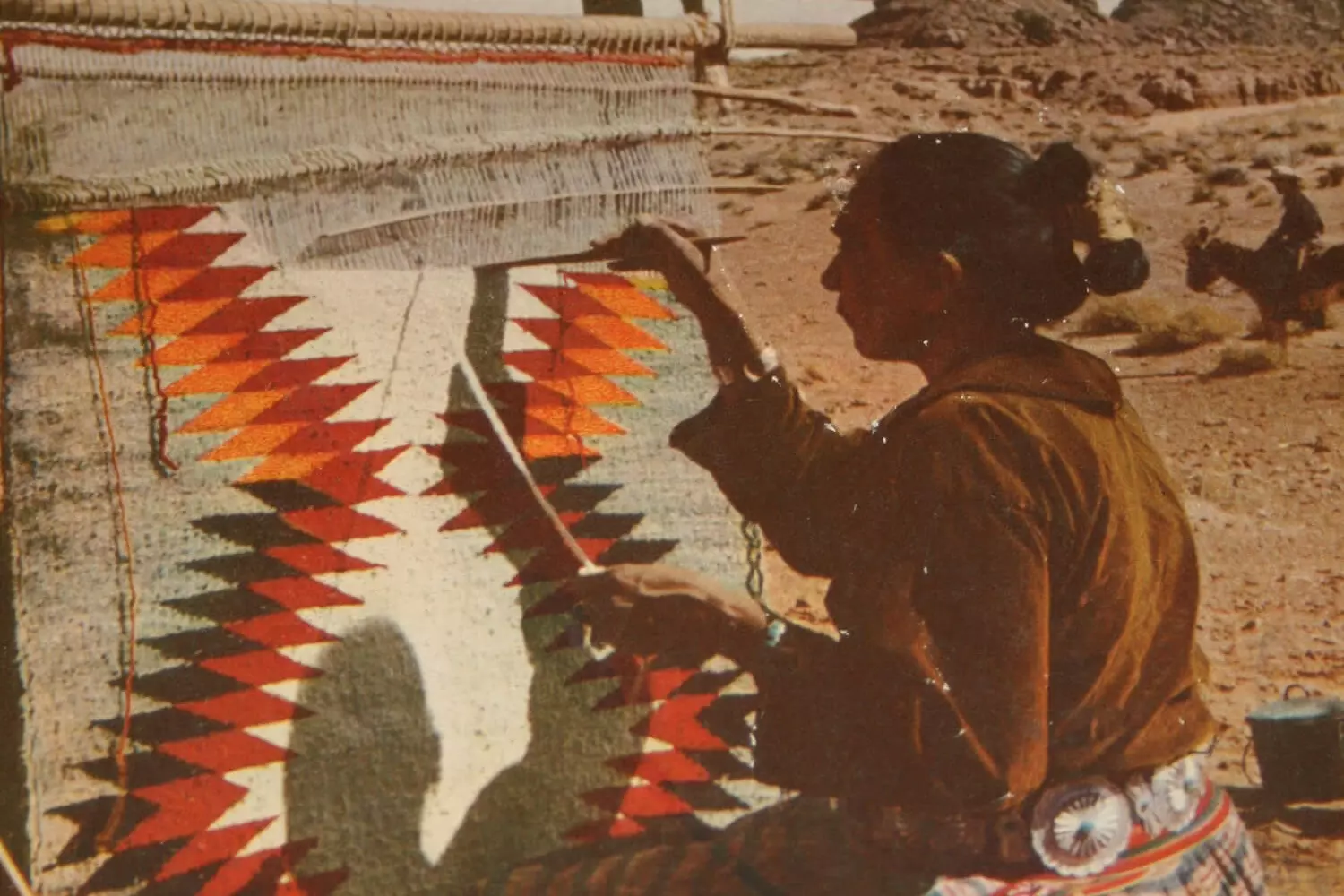 Navajo — masters of weaving and jewelry Navajo woman working on a traditional rug