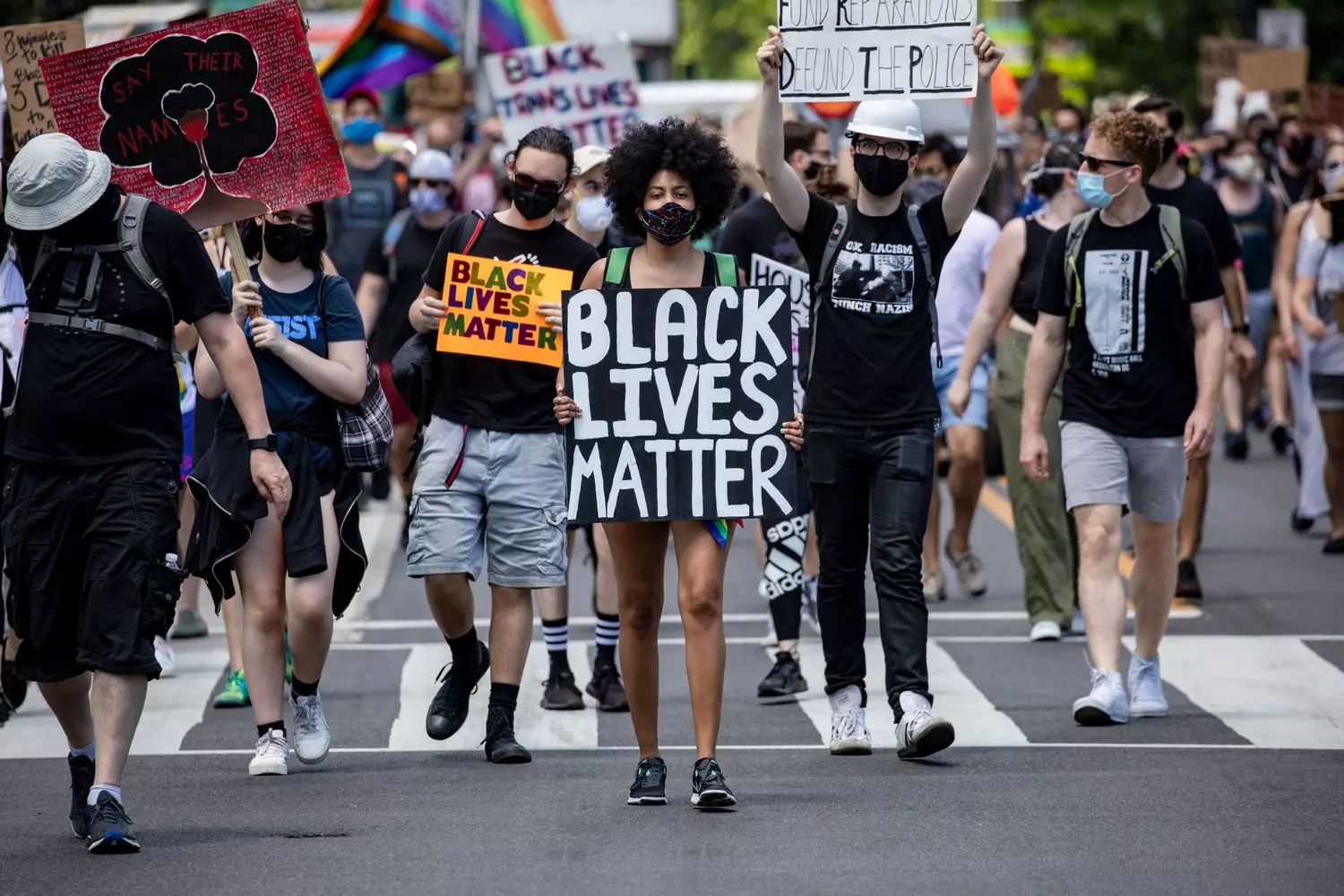Power in Unity: Scenes from Black Lives Matter Protests Worldwide Diverse crowd of Black Lives Matter demonstrators marching with signs and raised fists in urban setting, demanding racial justice and police reform