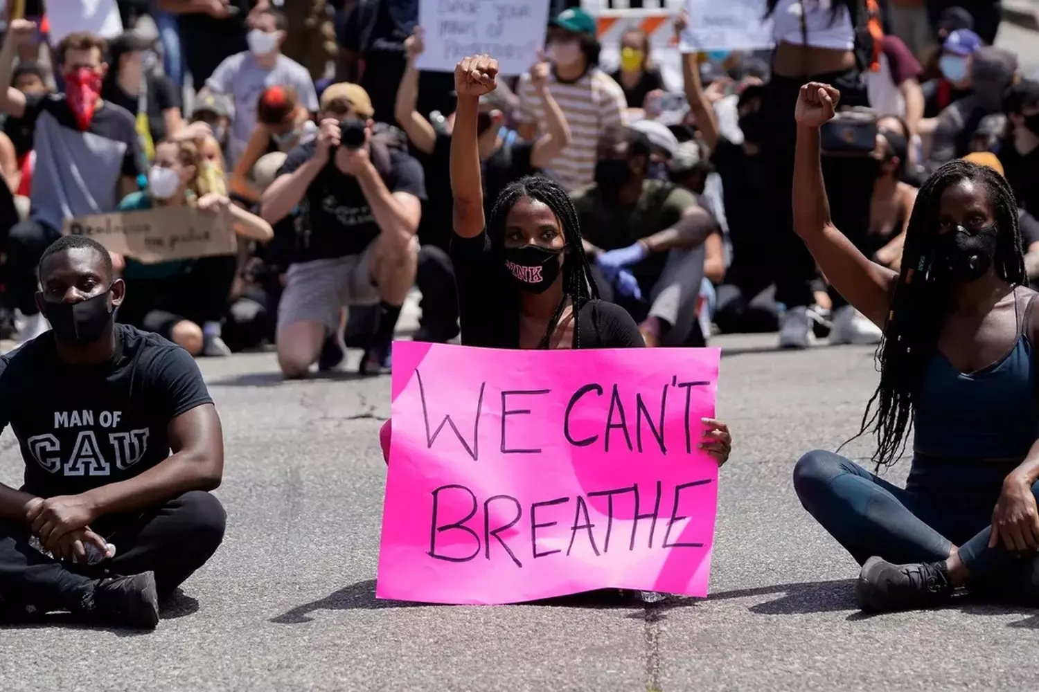 Power in Unity: Scenes from Black Lives Matter Protests Worldwide Diverse crowd of Black Lives Matter demonstrators marching with signs and raised fists in urban setting, demanding racial justice and police reform