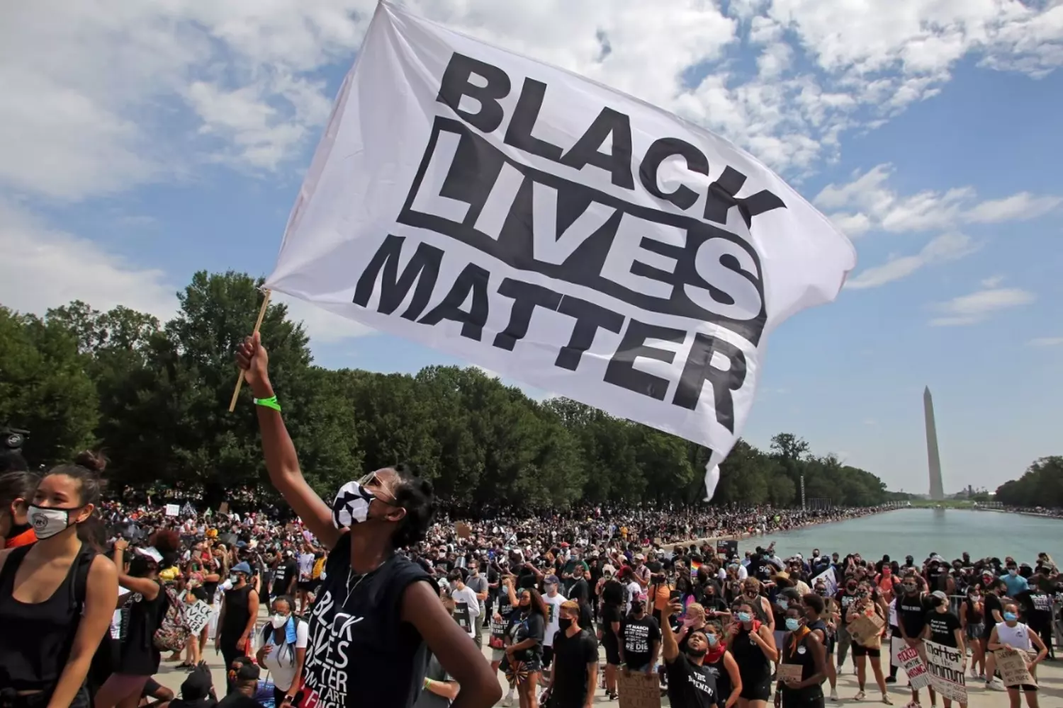 Power in Unity: Scenes from Black Lives Matter Protests Worldwide Diverse crowd of Black Lives Matter demonstrators marching with signs and raised fists in urban setting, demanding racial justice and police reform