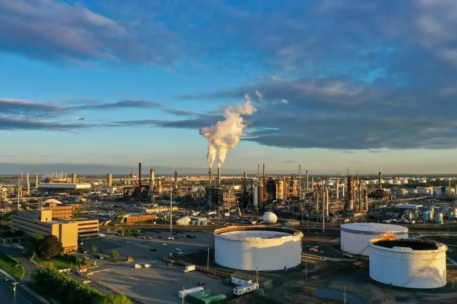 Oil Storage Terminal in the USA: Critical Hub of the Energy Infrastructure Aerial view of a large American oil storage terminal with multiple cylindrical tanks, pipelines, and loading docks, showcasing the scale of US fuel reserves