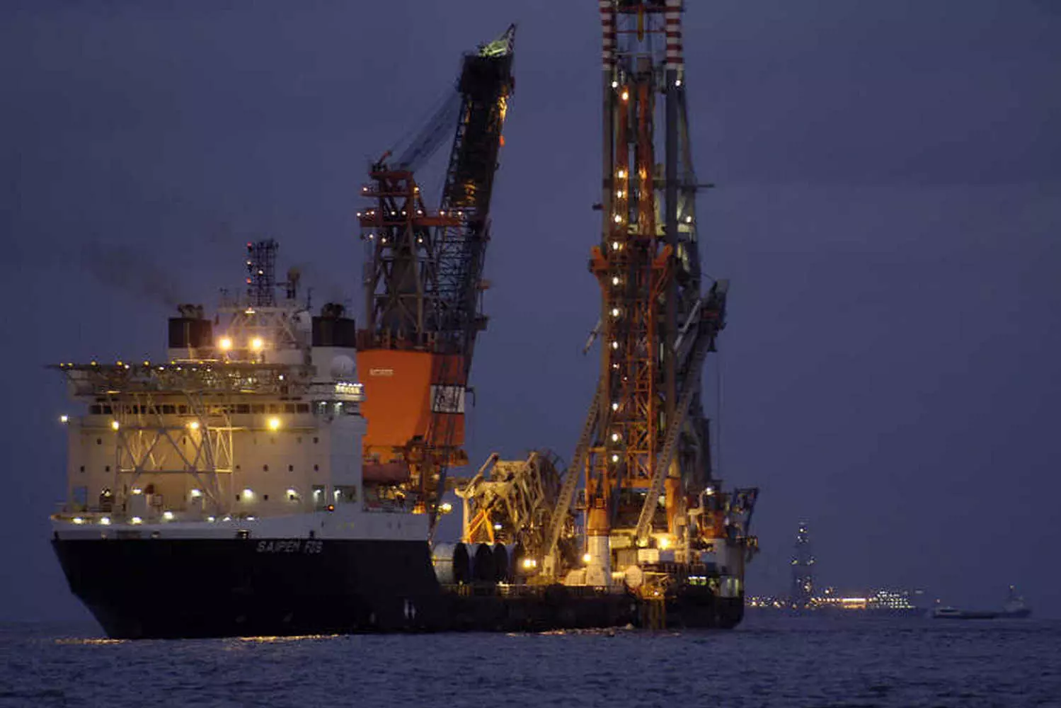 Offshore Oil Drilling in the USA: Energy Production from the Ocean Depths A massive offshore drilling platform in US waters, extracting crude oil from beneath the ocean floor with support ships nearby