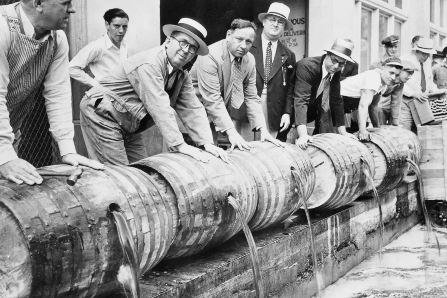 Pouring Out Prohibition: The Destruction of Illegal Alcohol in 1920s America A group of people pouring alcohol from wooden barrels onto the street during Prohibition in the US, 1920
