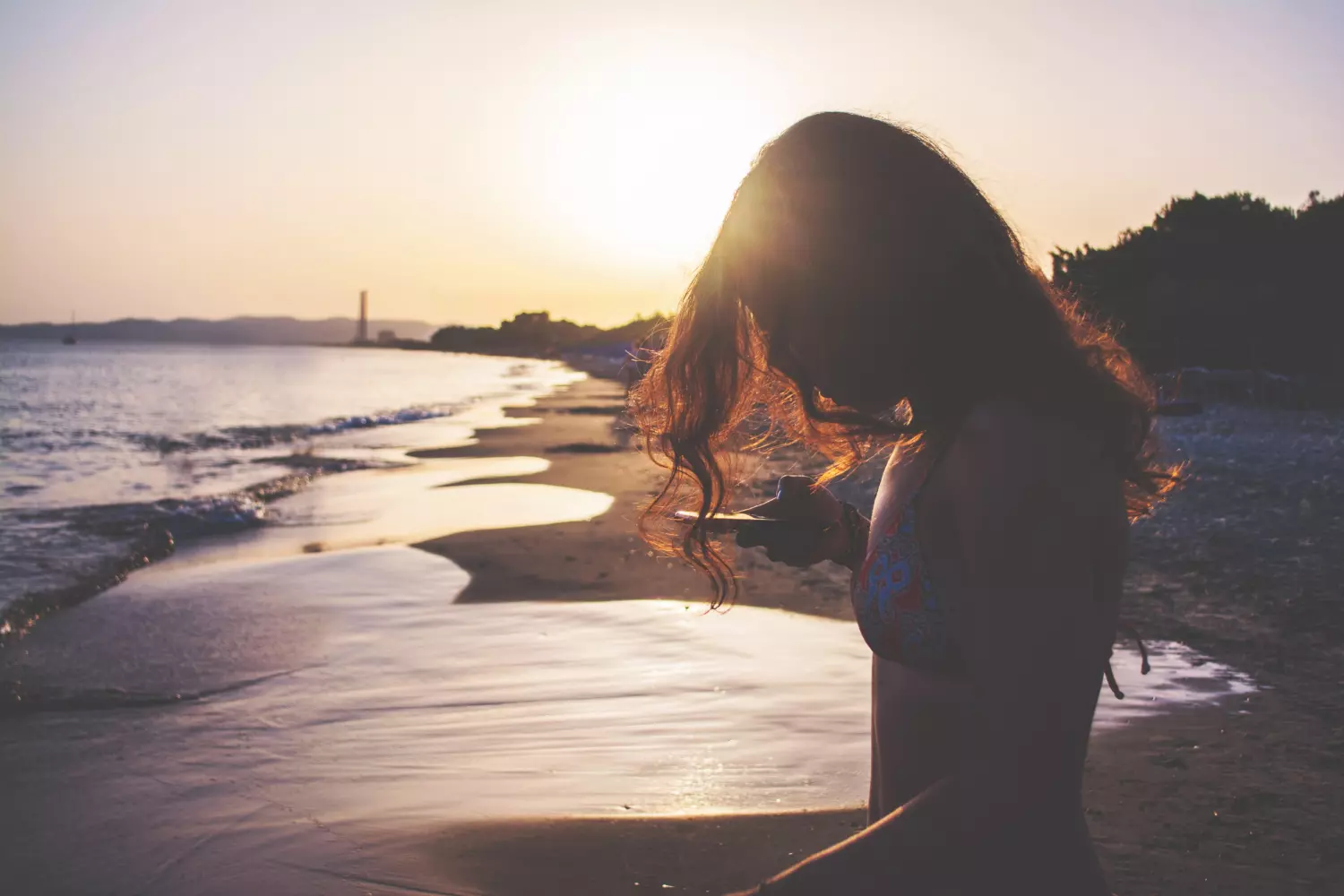 Mobile Apps in the USA for Leisure: Convenience and Functionality A Girl with a Phone on a Beach in the USA — Using Apps on Vacation