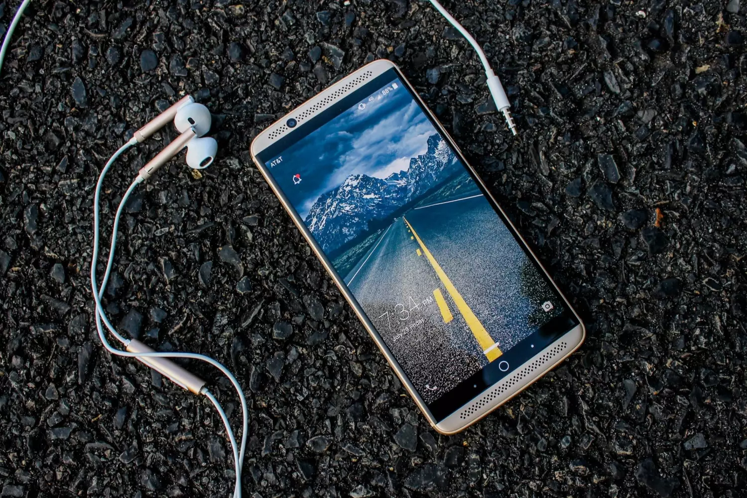 A Smartphone with Earphones: The Convenience of Mobile Apps in the USA A Smartphone with Earphones on Asphalt in the USA — A Stylish Accessory for Using Apps