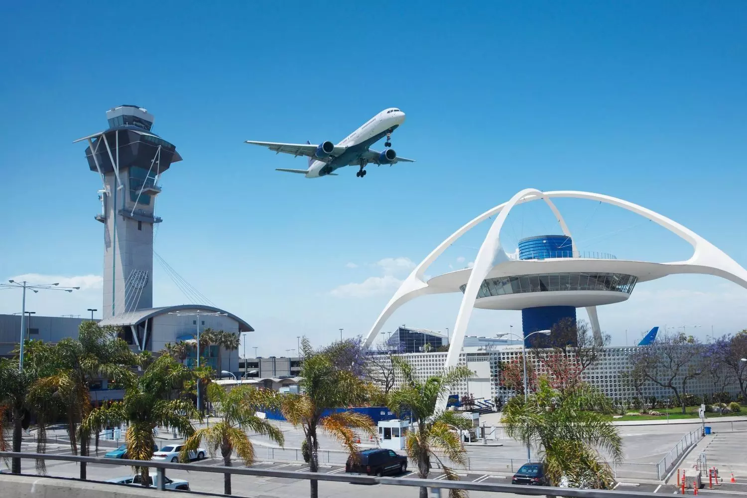 Los Angeles International Airport (LAX) — plane landing, control tower, and Theme Building A plane landing at Los Angeles International Airport (LAX) with the air traffic control tower and the iconic Theme Building in the background