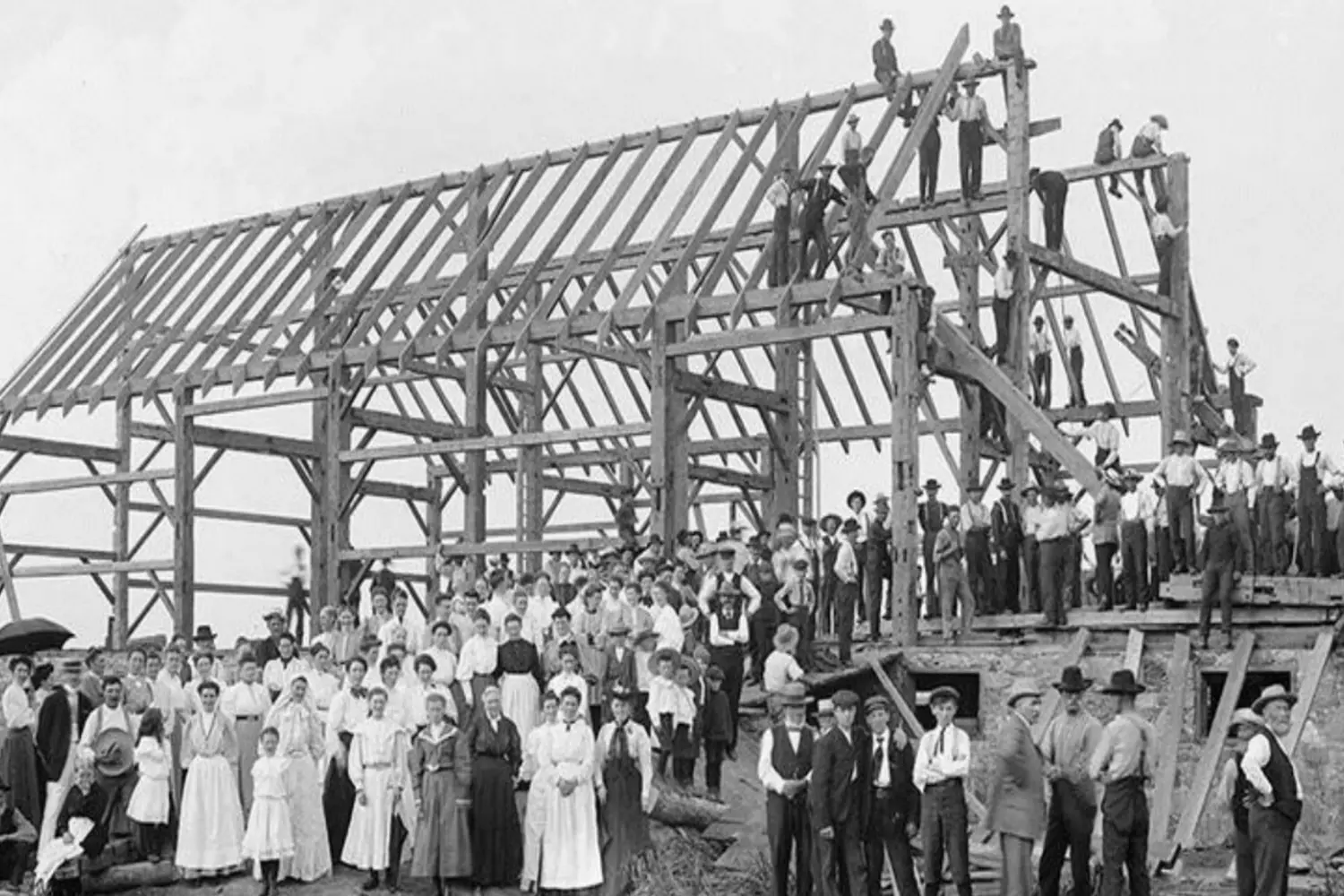 Amish Barn Raising: A Glimpse into Historic Community Building Vintage photo: Amish men constructing a house during a traditional "barn raising"