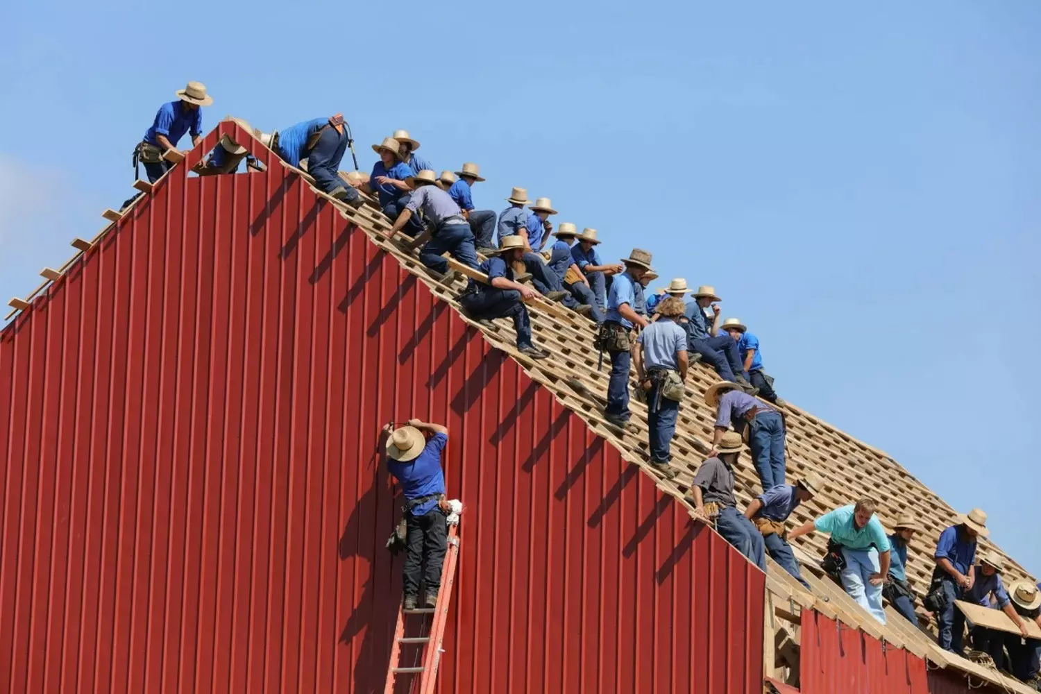 Skilled Amish craftsmen constructing a new home by hand Amish men building a traditional wooden house together