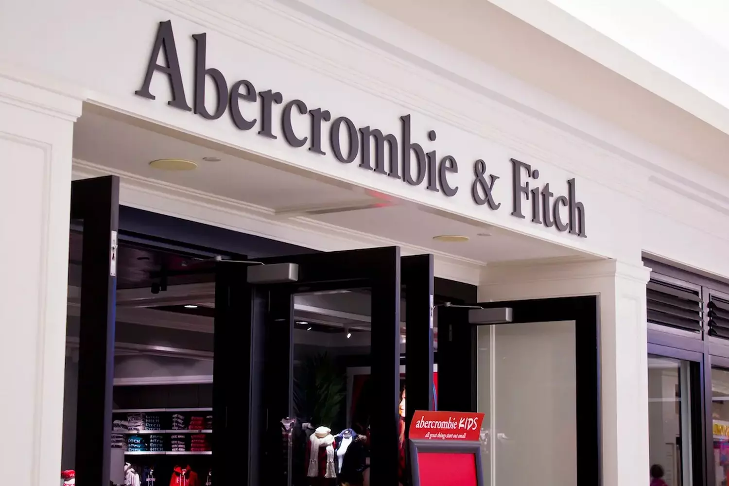 Магазин Abercrombie & Fitch: Утончённый кэжуал с намёком на роскошь Фото бутика Abercrombie & Fitch с фирменным тёмным фасадом, стильными витринами и атмосферой премиального стиля