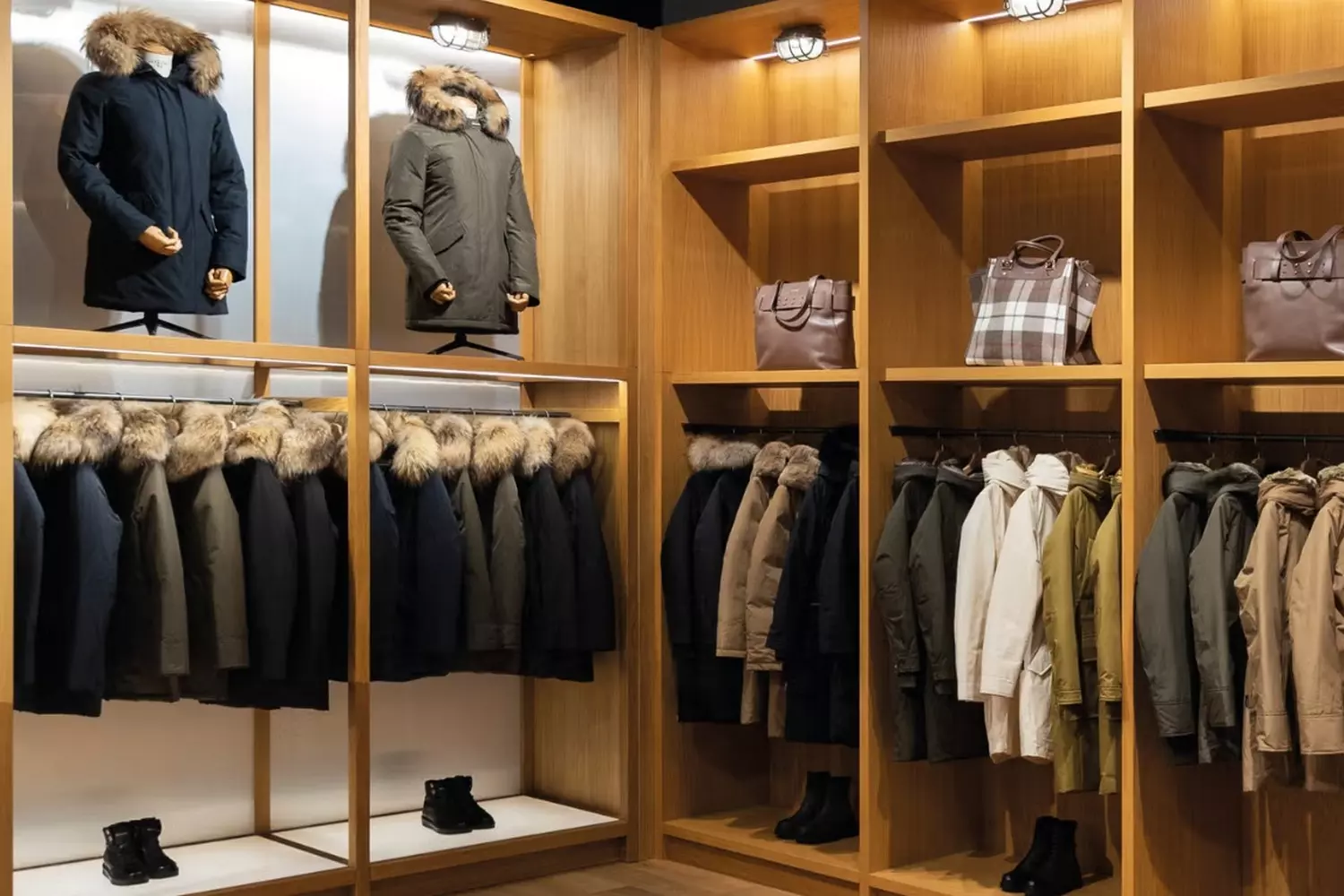 Магазин Woolrich: Наследие, проверенное временем и стихиями Фото бутика Woolrich с фирменной одеждой для активного отдыха: пуховики, рубашки в клетку и эко-материалы в природной эстетике