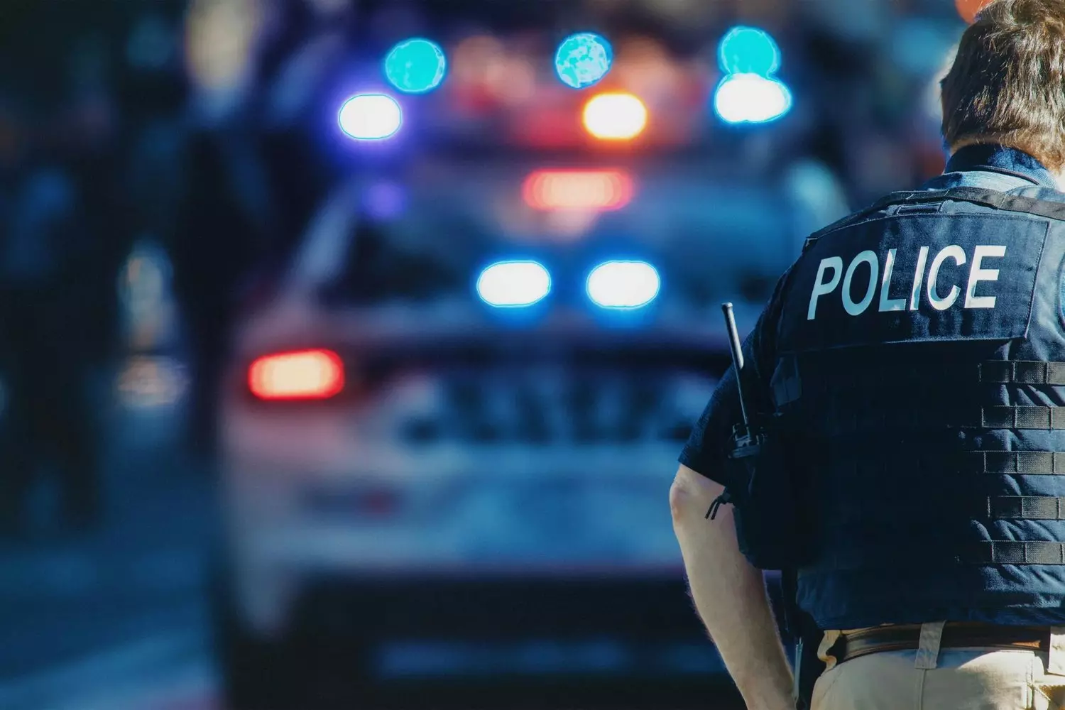 US Police Officer Standing with Back to Camera — Law Enforcement in America A uniformed US police officer seen from behind, representing authority and public safety in the United States
