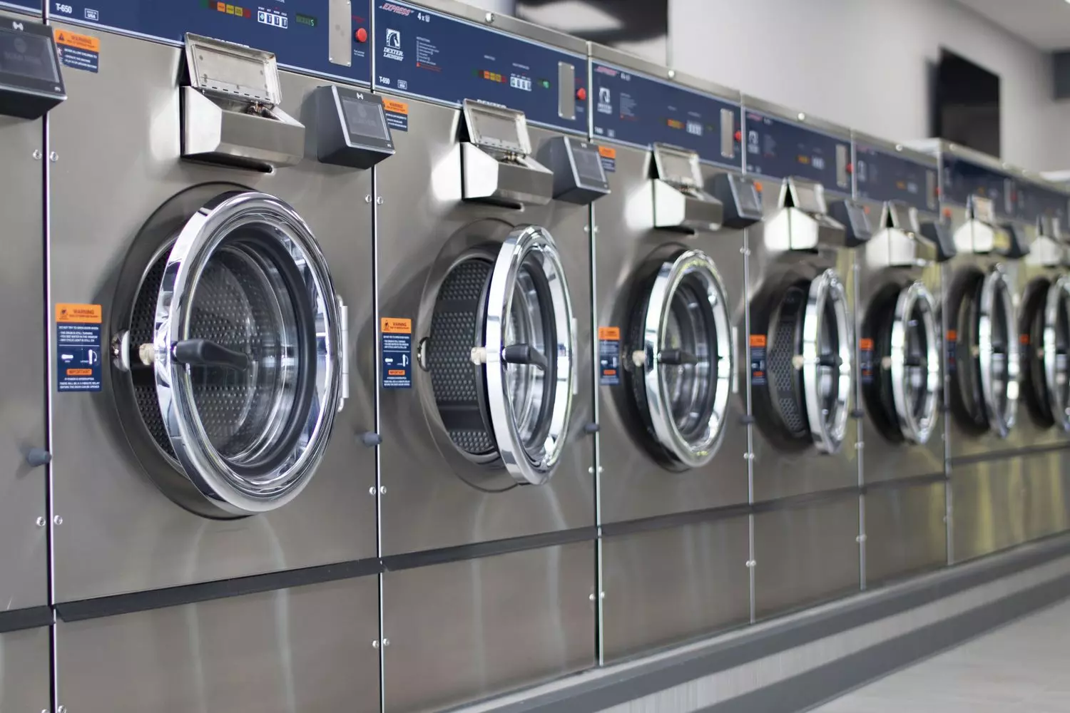 More Than Just Spin Cycles: Why American Laundromats Are Cultural Icons A vibrant laundromat in the USA with rows of washing machines, folding tables, and a cozy atmosphere — where laundry meets community