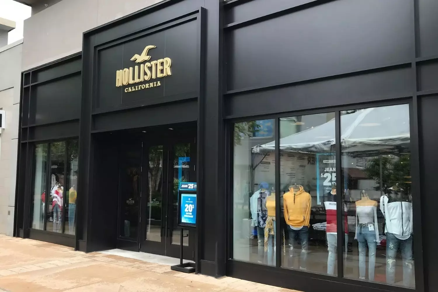 Hollister’s California surf-shop aesthetic Hollister Store: A California Beach Shack Vibe with Surfboard Decor, Weathered Wood Panels, and Mood Lighting Highlighting Denim & Hoodie Displays