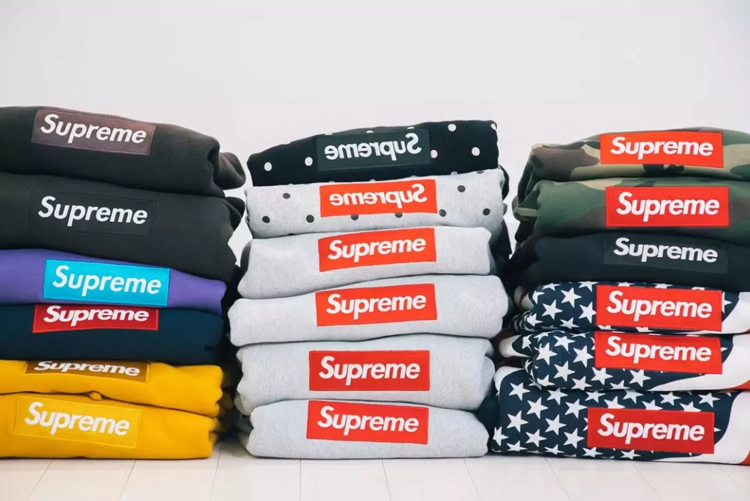 When your hoodies cost like a mortgage #SupremeCollection A stack of Supreme hoodies with the iconic Box Logo — red, black, and white models styled in a casual, laid-back way