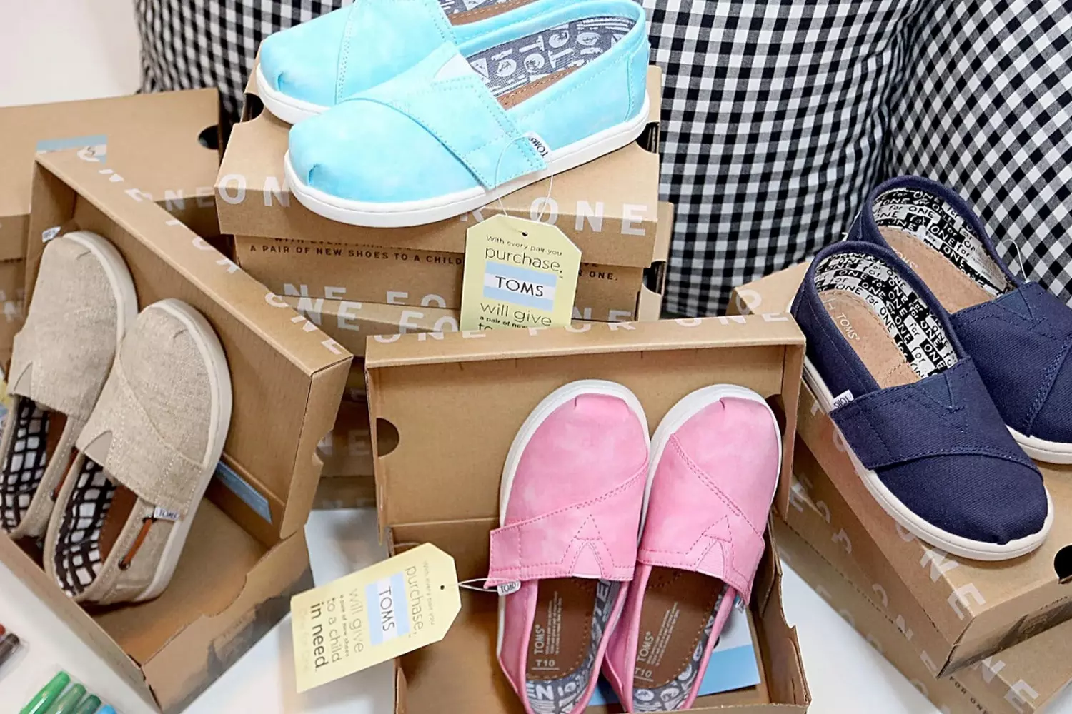 Shoes with a kind heart Classic TOMS espadrilles in natural cotton with jute soles, set against a beach sunset backdrop — embodying the brand’s signature style and philosophy