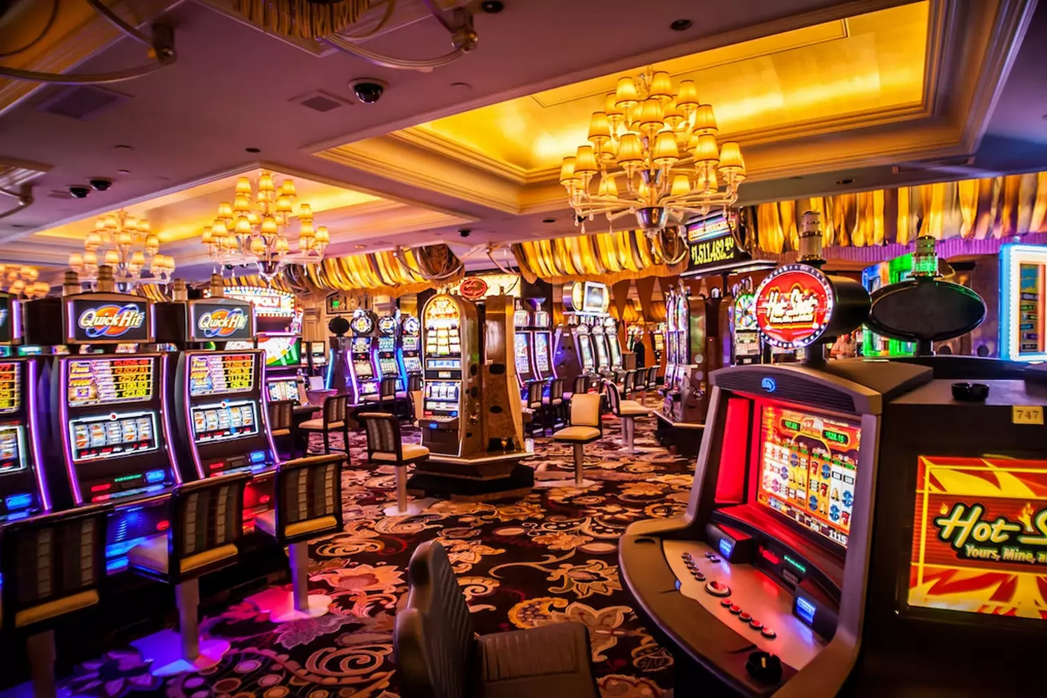 Casino slot machines with vibrant lights Row of colorful slot machines inside a casino with bright lights