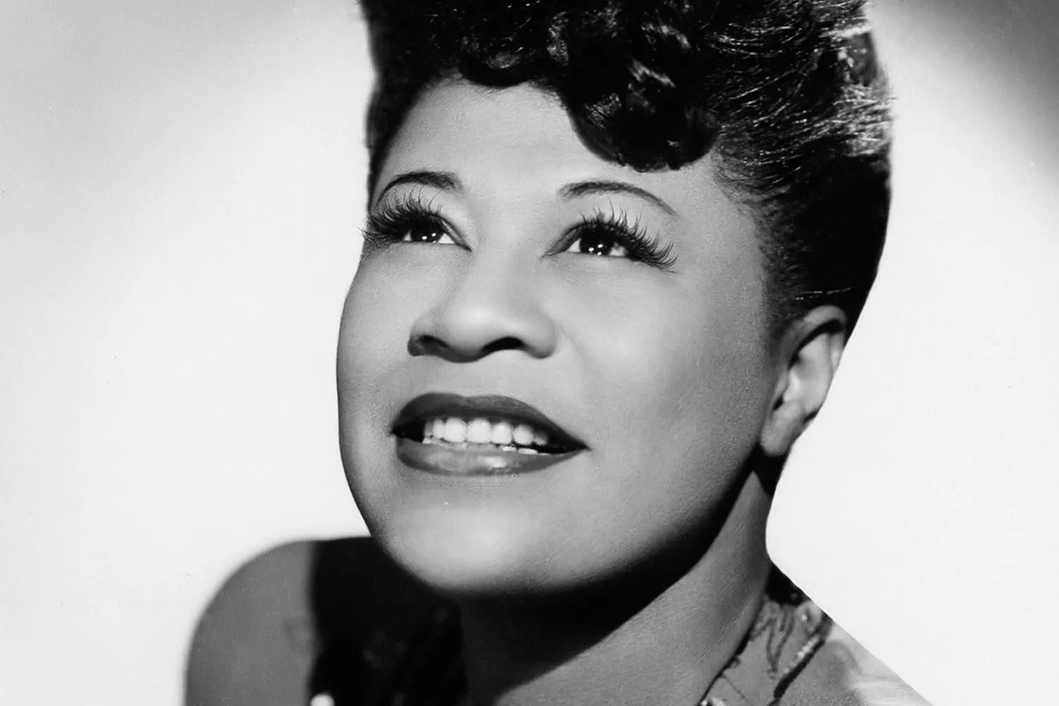 Ella Fitzgerald: The Timeless Voice of Jazz Black-and-white portrait of jazz legend Ella Fitzgerald smiling warmly