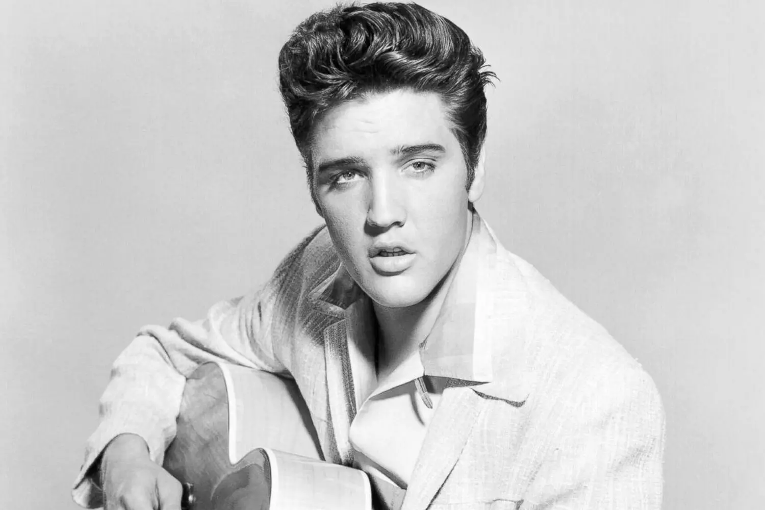 Iconic moment: Elvis Presley with his guitar on stage Elvis Presley playing guitar