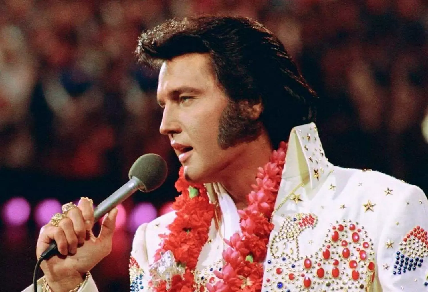 Elvis Presley live in Las Vegas wearing his iconic white stage outfit Elvis Presley performing on stage in a white jumpsuit