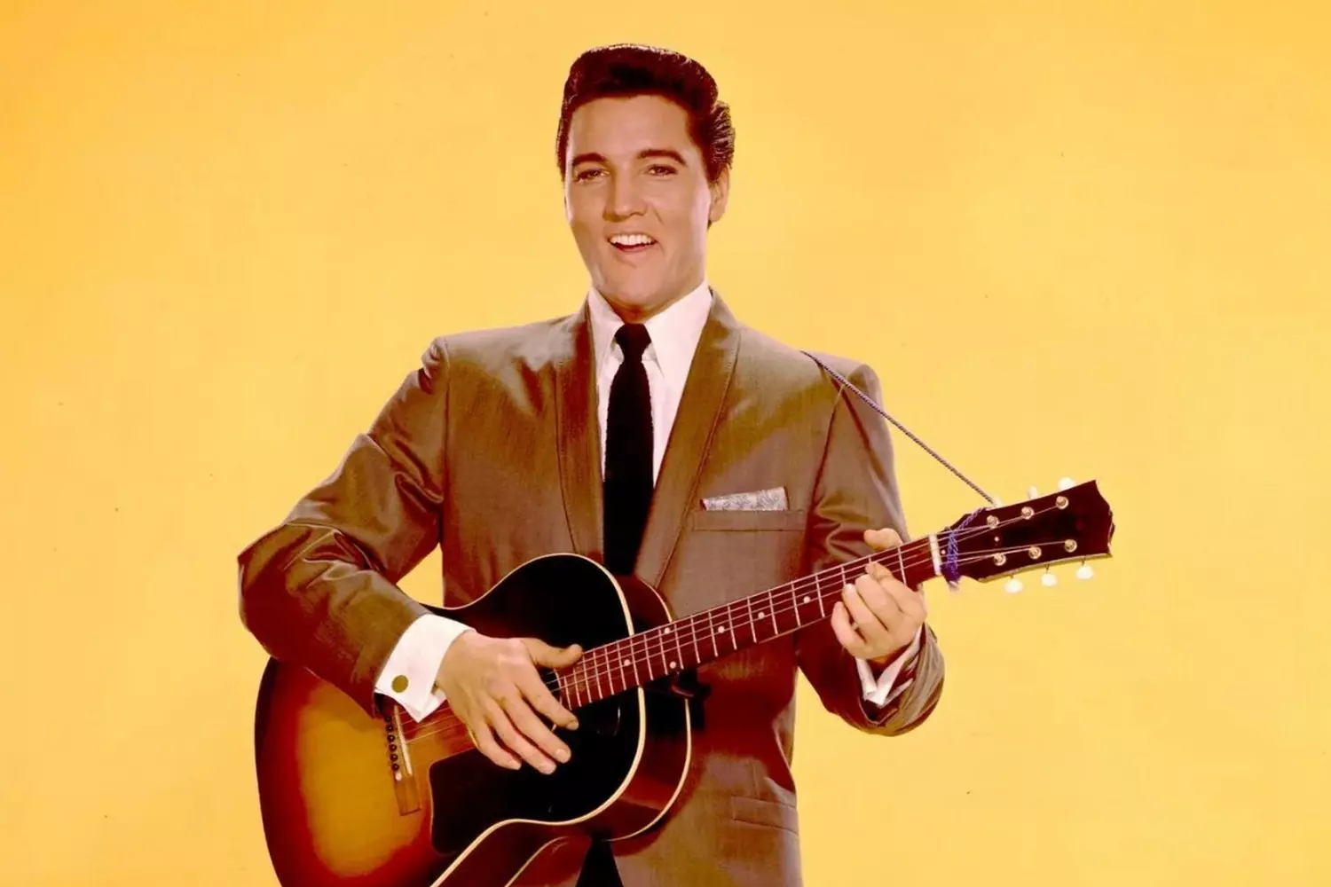Iconic moment: Elvis Presley with his guitar on stage Elvis Presley playing guitar