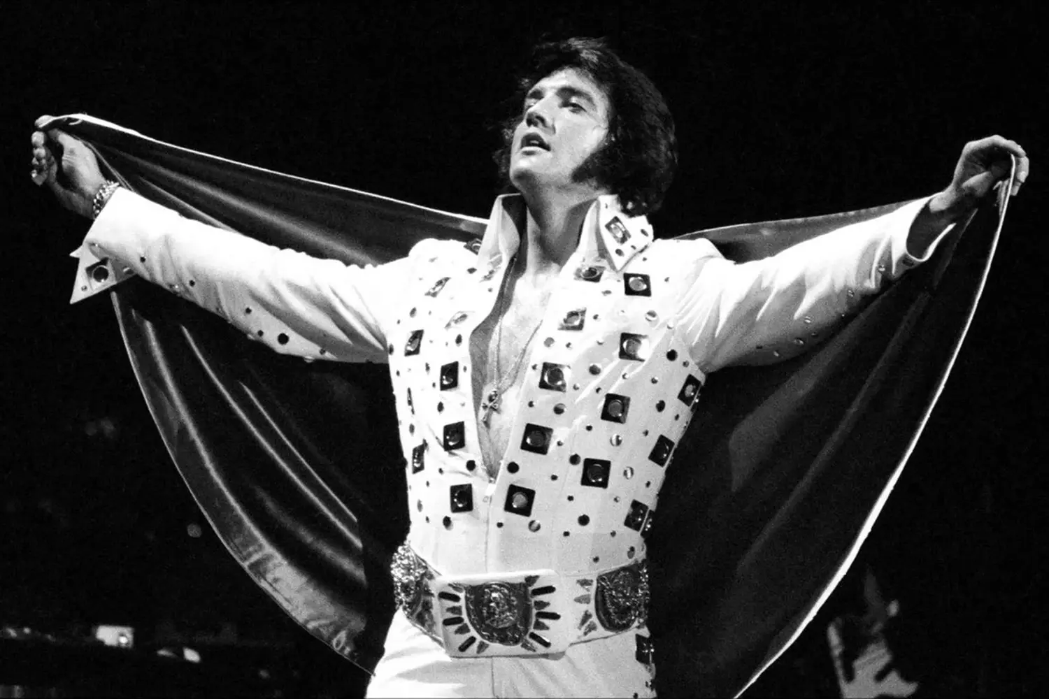 Elvis Presley live in Las Vegas wearing his iconic white stage outfit Elvis Presley performing on stage in a white jumpsuit