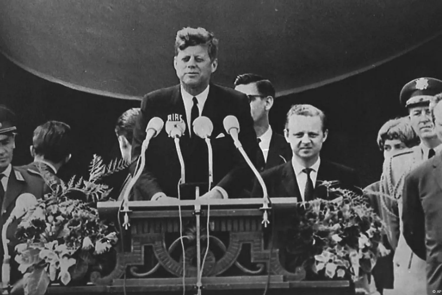 Kennedy Mid-Speech: Presidential Charisma in Action President John F. Kennedy in the midst of a fiery speech: his expressive facial features and confident posture showcase the signature oratory style that captivated a nation