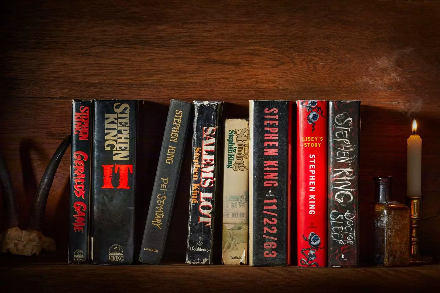 Stephen King's Literary Universe: A Shelf of Nightmares A curated collection of Stephen King's novels neatly arranged on a bookshelf, showcasing iconic titles from Carrie to The Shining and beyond