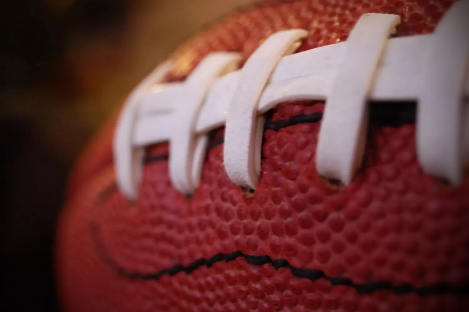 A close-up of an American football with white laces A close-up of an American football with white laces