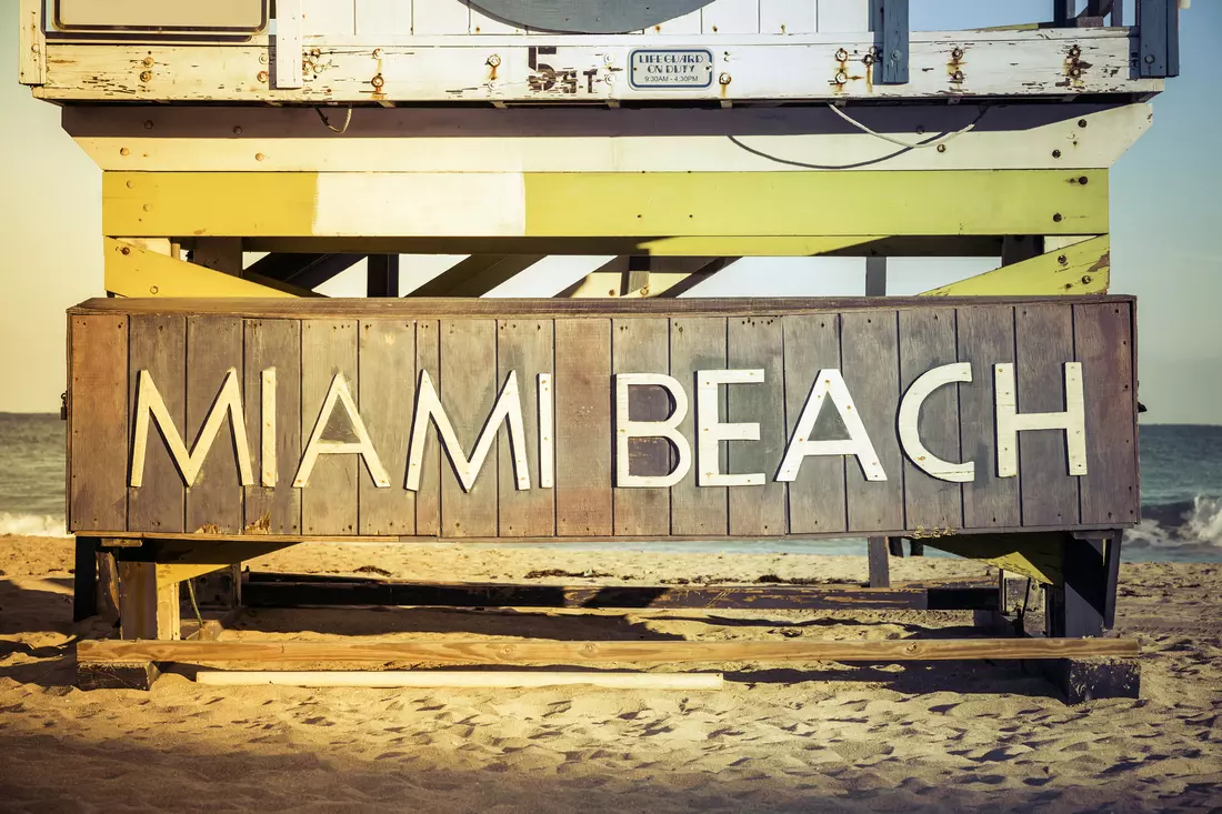 Miami Beach Sign — Welcome to Miami's Shores — American Butler Close up of Miami Beach sign on wooden lifeguard tower